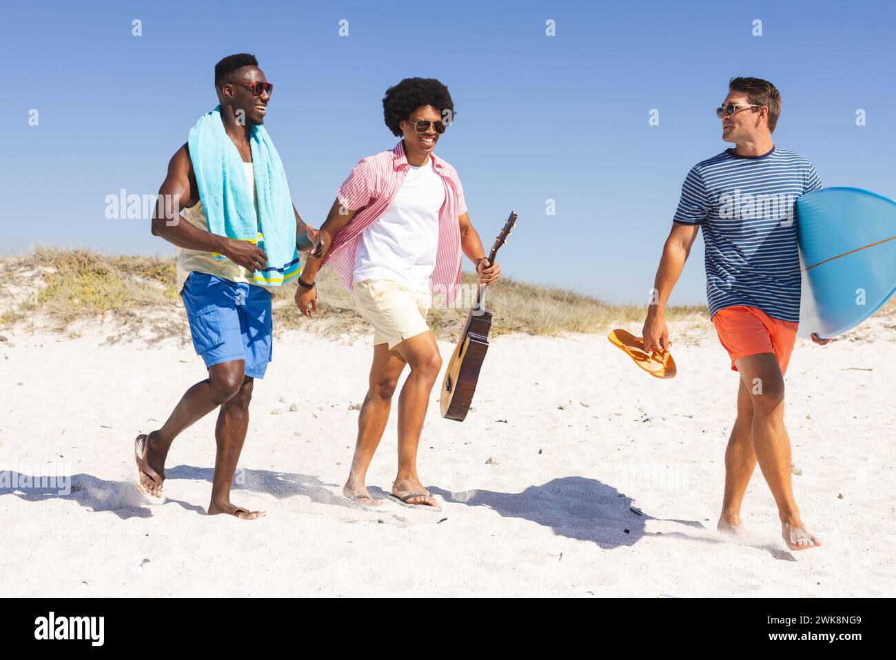 Divers amis profitent d'une journée ensoleillée à la plage Banque D'Images