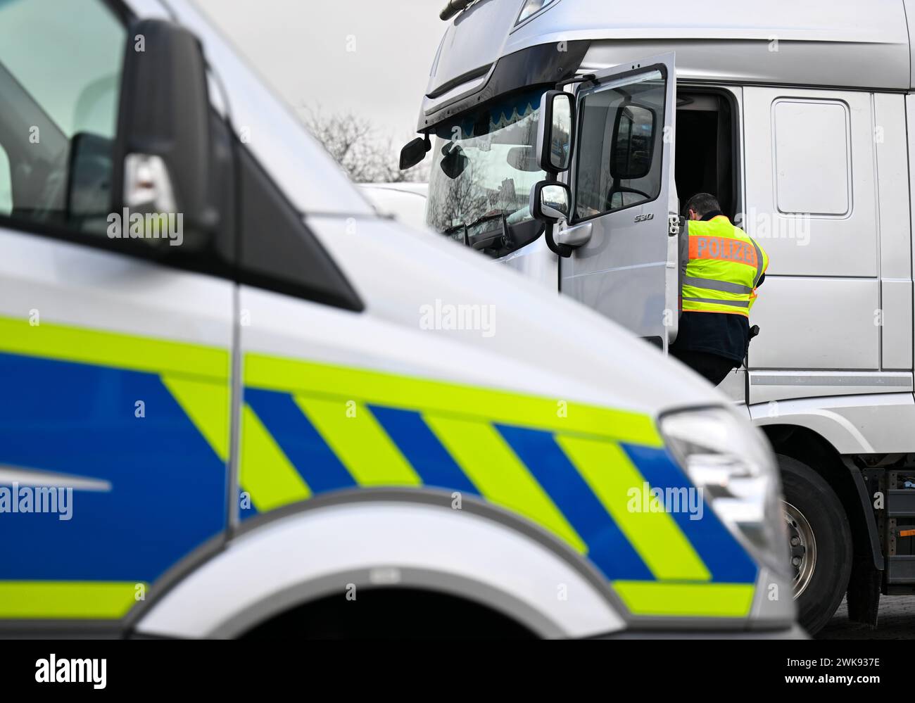 19 février 2024, Saxe-Anhalt, Könnern : un policier inspecte un camion dans le parking de Plötzetal sur l'A14. Cette semaine, il y aura plus de contrôles sur les routes en Saxe-Anhalt. La police de Saxe-Anhalt participe à la semaine internationale de contrôle Roadpol « Truck & bus ». Jusqu'à dimanche, les officiers se concentreront en particulier sur le transport commercial de passagers et de marchandises. L'accent est mis sur le respect des périodes de conduite et de repos par les conducteurs professionnels, l'état technique des véhicules et la sécurité du chargement. Photo : Hendrik Schmidt/dpa Banque D'Images