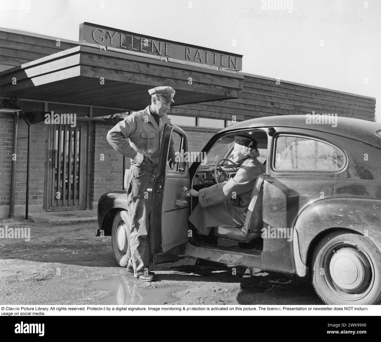 Premier motel de Suède 1956. Le premier motel de Suède situé près de l'autoroute E4 à Fruängen, dans le sud de Stockholm. Les architectes Börge Glahn et Ole Helweg se sont inspirés des motels des États-Unis où la voiture était au centre et que vous gariez juste à côté de votre chambre d’hôtel. Une femme dans sa voiture est accueillie et reçoit des instructions sur l'endroit où garer sa voiture. 1956 *** légende locale *** © Classic Picture Library. Tous droits réservés. Protégé par une signature numérique. La surveillance et la protection de l'image sont activées sur cette image. La licence ; la présentation ou le bulletin d'information N'inclut PAS l'utilisation Banque D'Images