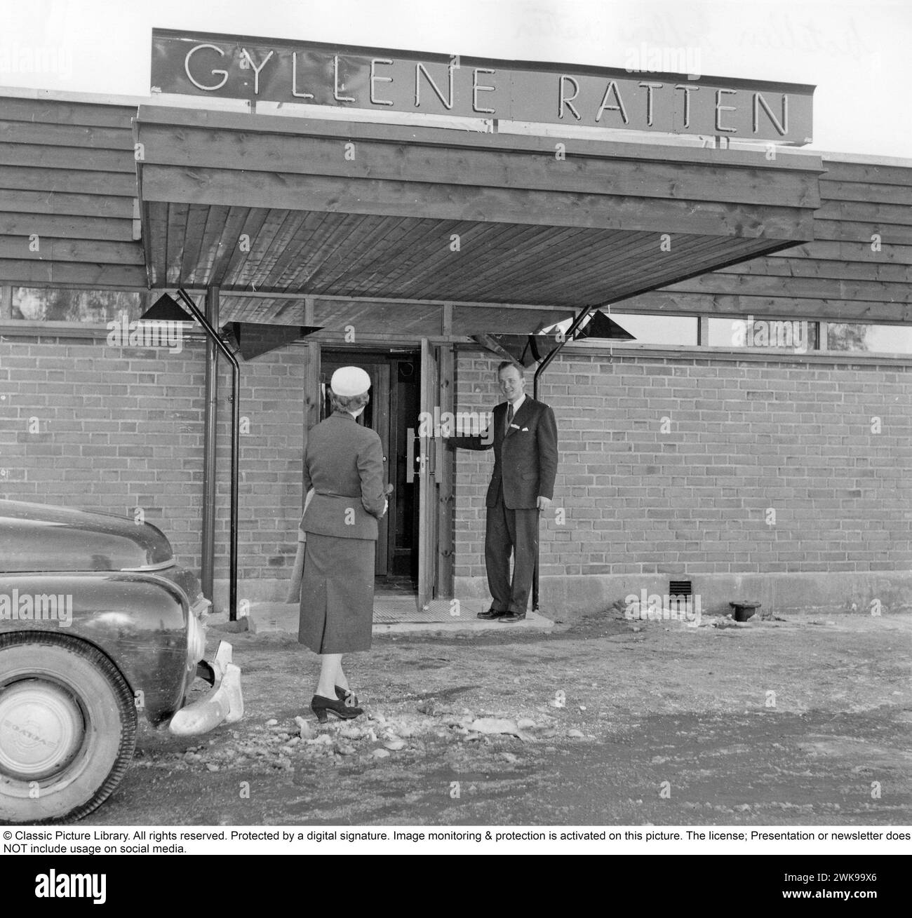 Premier motel de Suède 1956. Le premier motel de Suède situé près de l'autoroute E4 à Fruängen, dans le sud de Stockholm. Les architectes Börge Glahn et Ole Helweg se sont inspirés des motels des États-Unis où la voiture était au centre et que vous gariez juste à côté de votre chambre d’hôtel. Une femme dans sa voiture est accueillie et reçoit des instructions sur l'endroit où garer sa voiture. 1956 *** légende locale *** © Classic Picture Library. Tous droits réservés. Protégé par une signature numérique. La surveillance et la protection de l'image sont activées sur cette image. La licence ; la présentation ou le bulletin d'information N'inclut PAS l'utilisation Banque D'Images