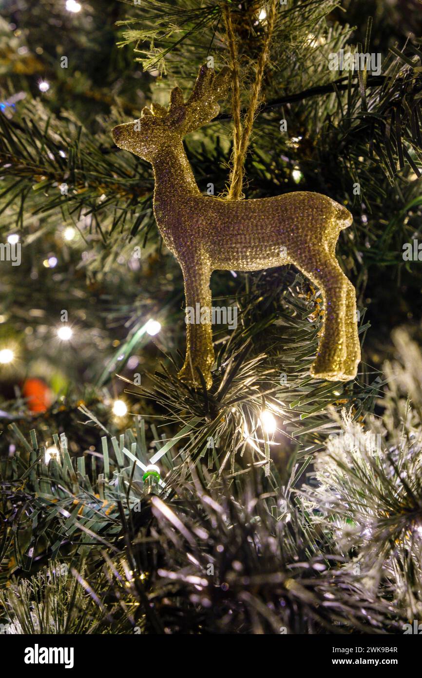 Une décoration de noël de renne accrochée à un arbre artificiel. Banque D'Images