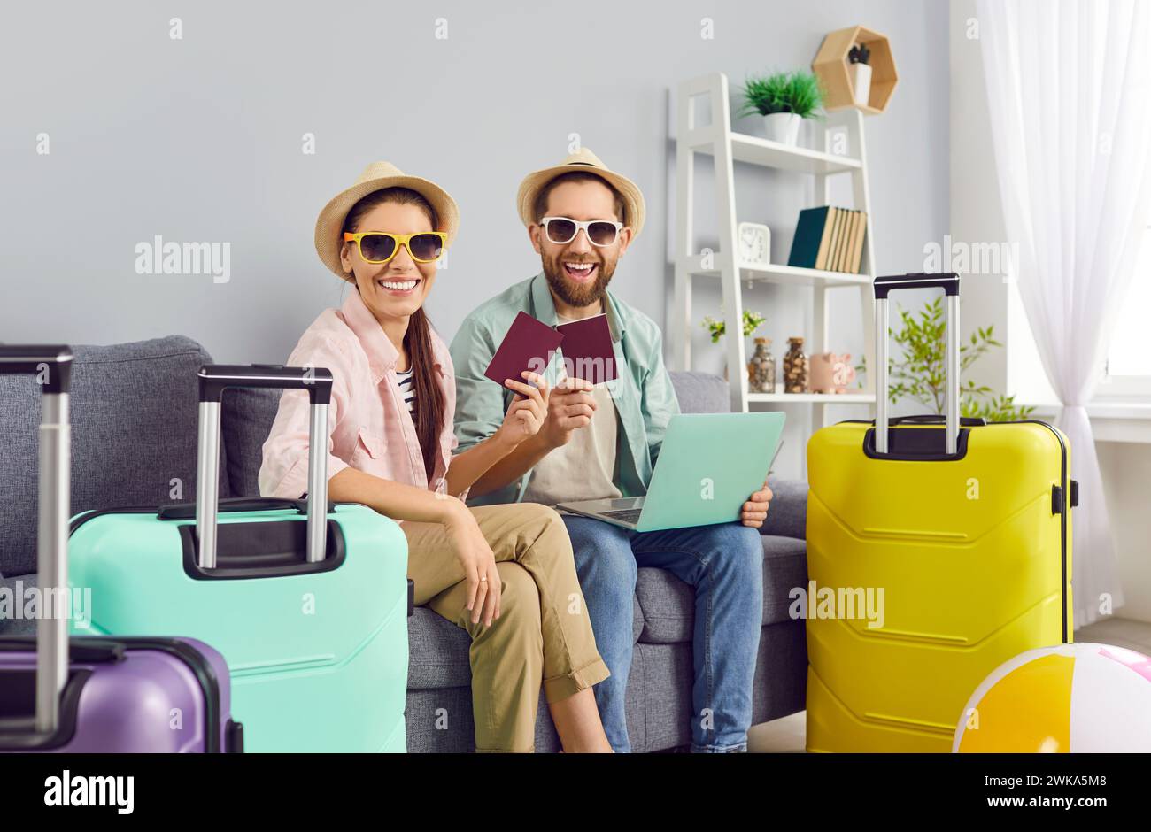Couple joyeux avec passeports et valises emballées est prêt pour les vacances d'été tant attendues. Banque D'Images