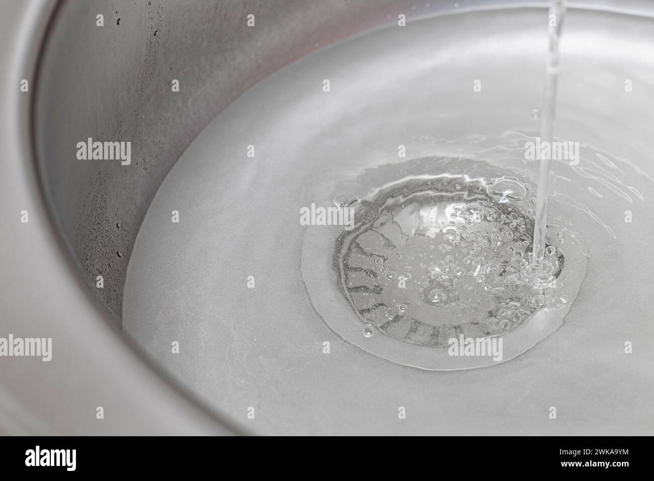 un évier avec un trou de vidange fermé est rempli d'eau. évier de cuisine rempli d'eau. bouchon de vidange d'évier Banque D'Images