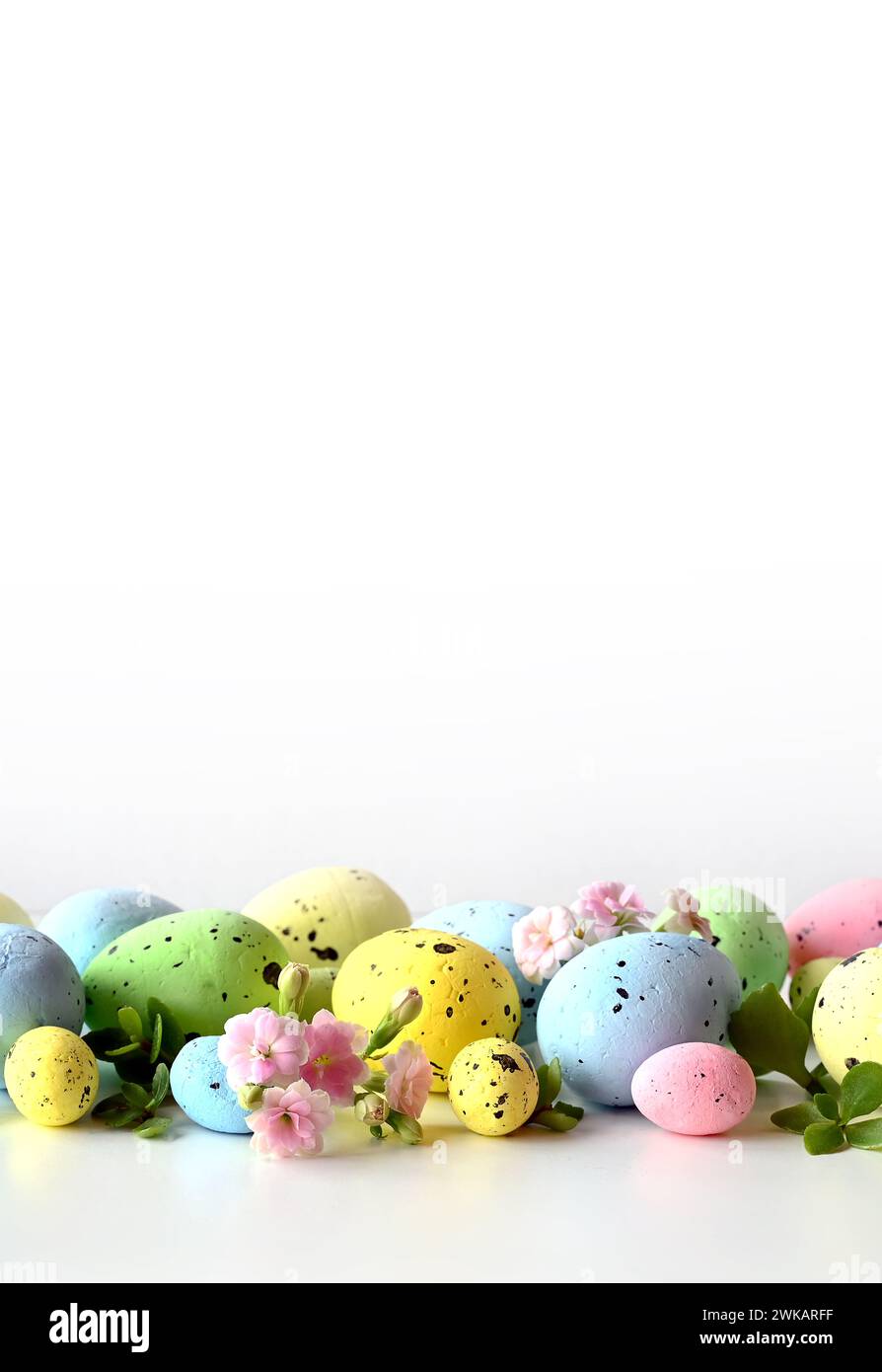 Collection d'oeufs de couleurs élégantes avec des fleurs pour la célébration de Pâques sur fond blanc. Concept de vacances. Banque D'Images