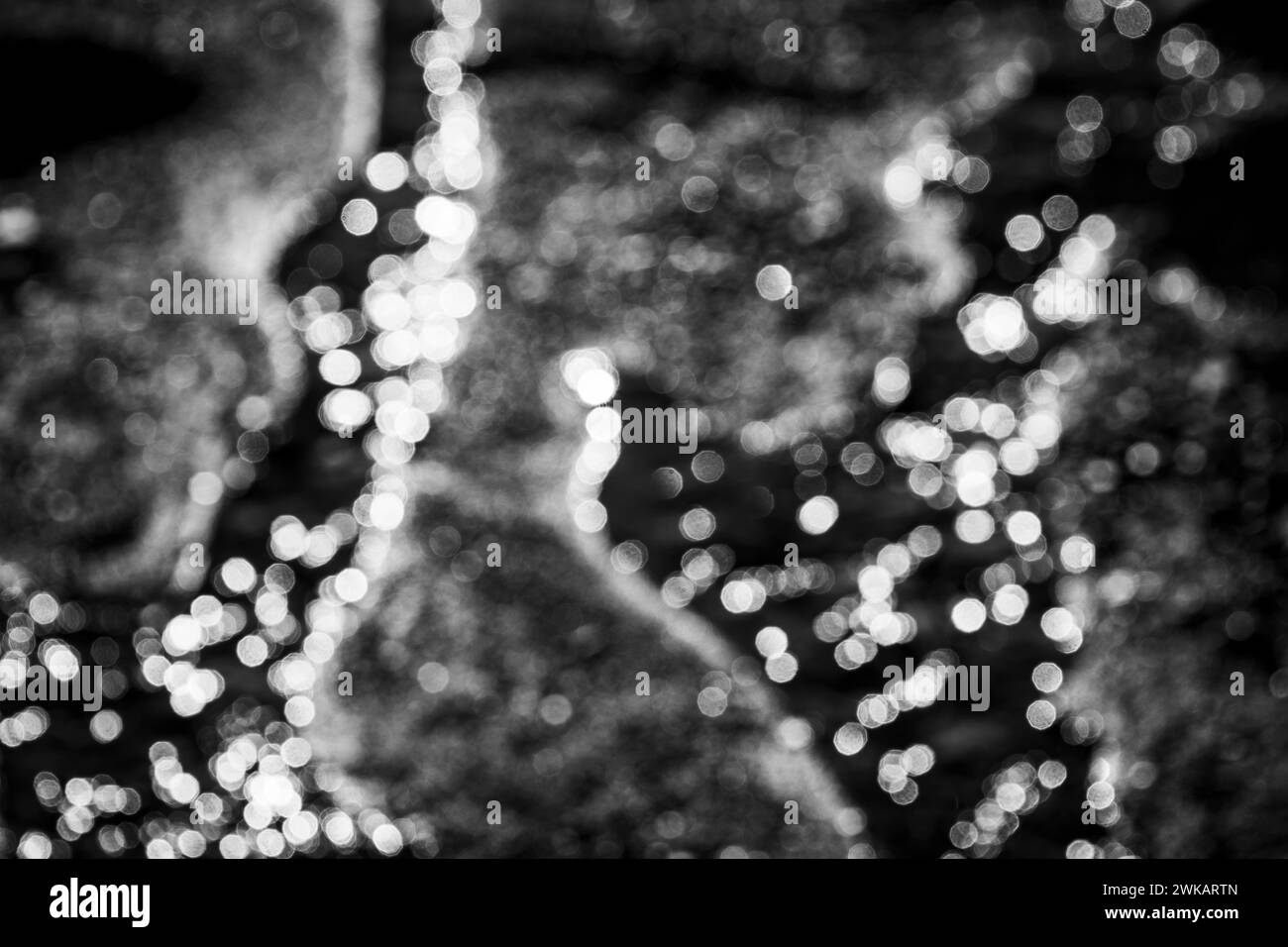 Le rendu flou des reflets de la lumière du soleil sur l'eau produit un effet bokeh spéculaire dans les hautes lumières. Banque D'Images