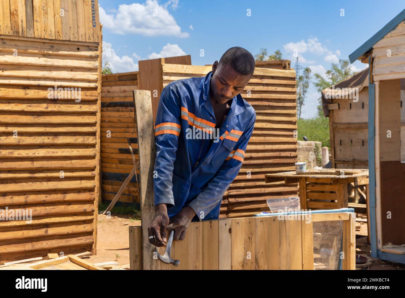 ouvrier charpentier afro-américain sur son lieu de travail, il fait des maisons de wendy , des maisons de chien, sur le bord de la route, vendeur de rue avec une petite busine Banque D'Images