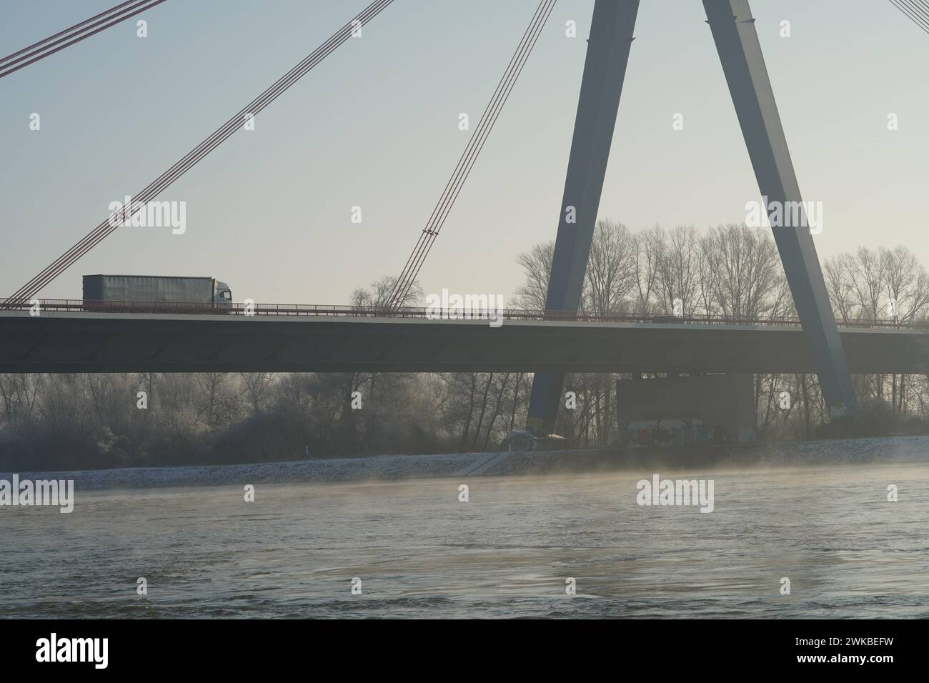 Guider un camion sur un pont animé tandis qu'un ferry glisse gracieusement le long du Rhin qui coule en contrebas. Banque D'Images