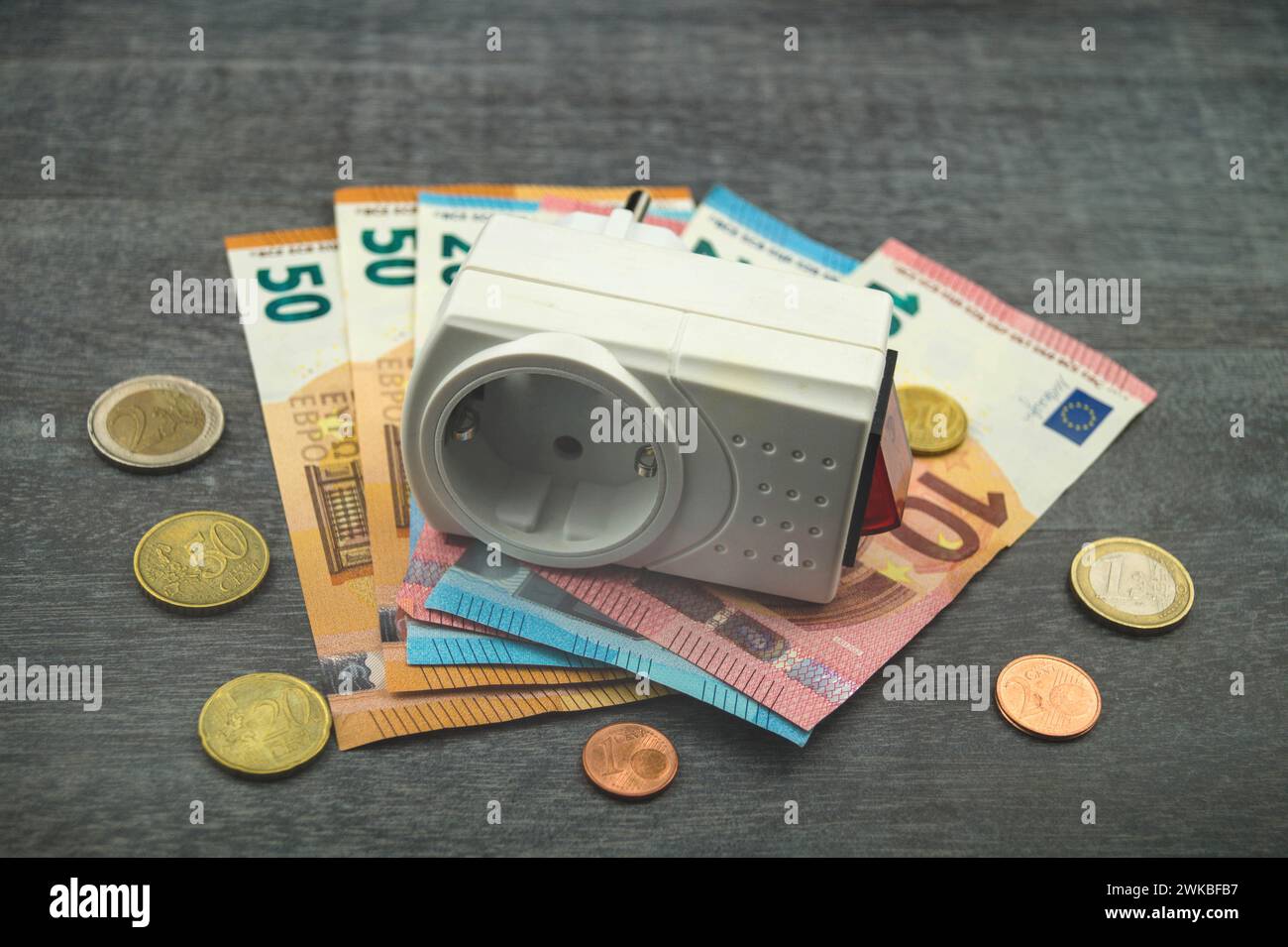 Socket et argent, image symbolique des coûts de l'électricité Banque D'Images