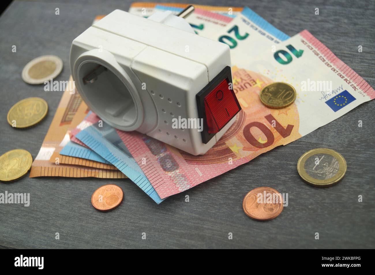 Socket et argent, image symbolique des coûts de l'électricité Banque D'Images