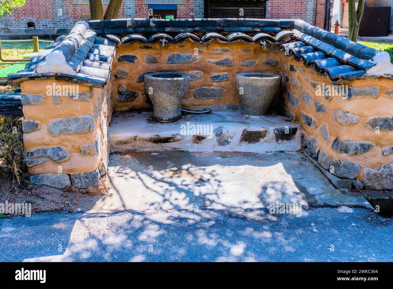 Fontaines d'eau publiques dans une alcôve de boue et de pierre avec des murs carrelés en céramique en Corée du Sud Banque D'Images