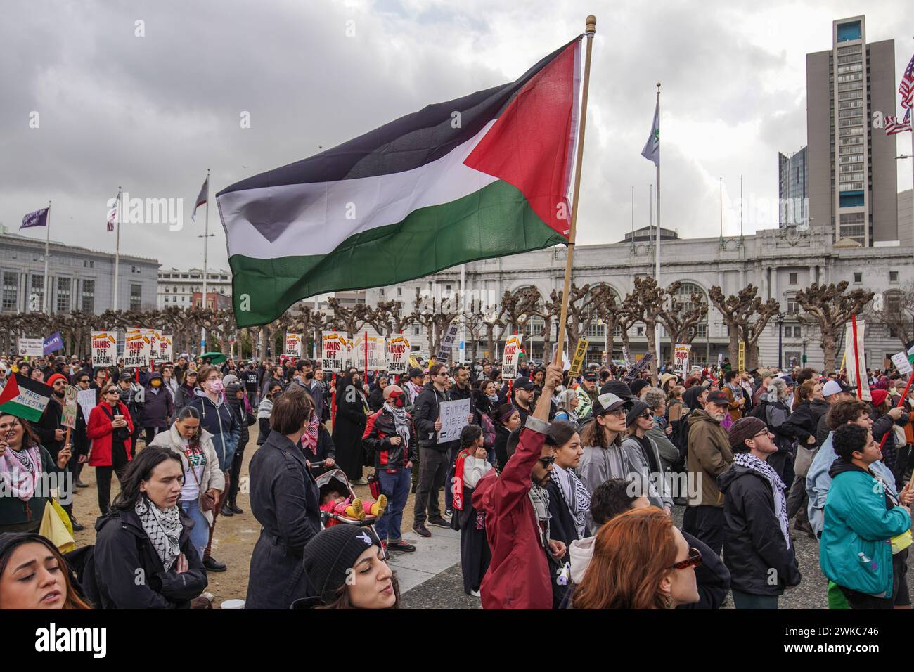 San Francisco, États-Unis. 19 février 2024. Les manifestants se rassemblent devant la mairie avec des pancartes et des drapeaux. Des milliers de manifestants pro-palestiniens se sont rassemblés pour une marche à San Francisco, coïncidant avec la journée du président des États-Unis. Leurs principales revendications comprenaient un cessez-le-feu dans la région de Gaza et la cessation de l'aide à Israël de la part de l'administration Biden. Crédit : SOPA images Limited/Alamy Live News Banque D'Images