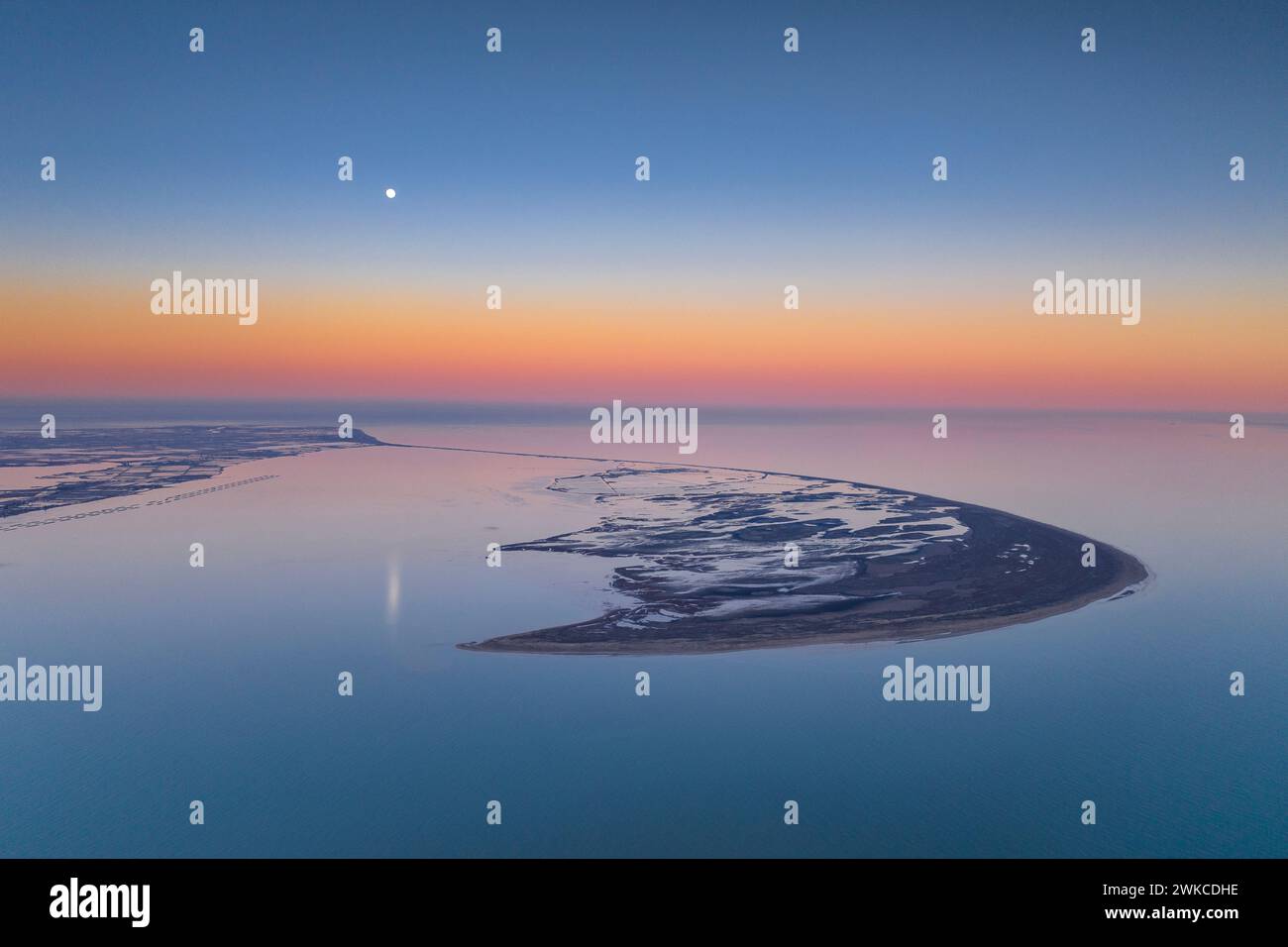 Vue aérienne sur la Punta de la Banya sur un coucher de soleil d'hiver avec la pleine lune dans le delta de l'Èbre (Tarragone, Catalogne, Espagne) Banque D'Images