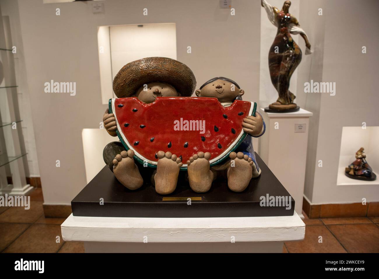 Il s'agit d'une œuvre d'art en céramique dans une galerie d'art mexicaine représentant un couple mexicain mangeant une pastèque. Banque D'Images