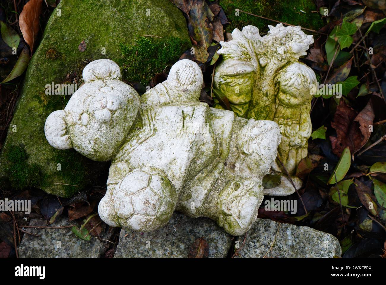 Une statue d'ours dans un habitat naturel, entouré de rochers et de feuillage dans la forêt Banque D'Images