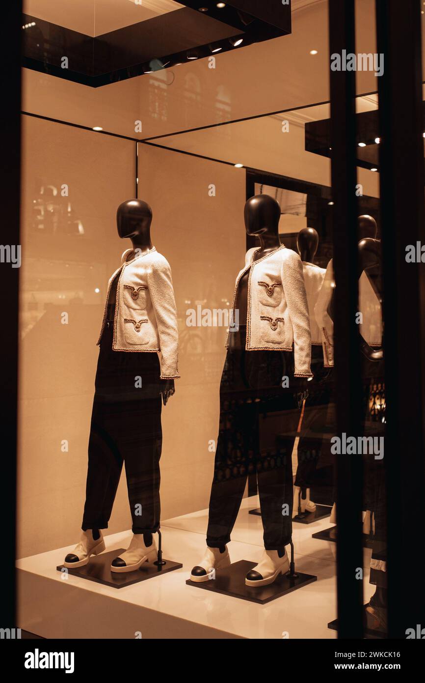 Mannequins élégants noirs dans une vitrine de boutique habillés d'une veste blanche et d'un pantalon Banque D'Images