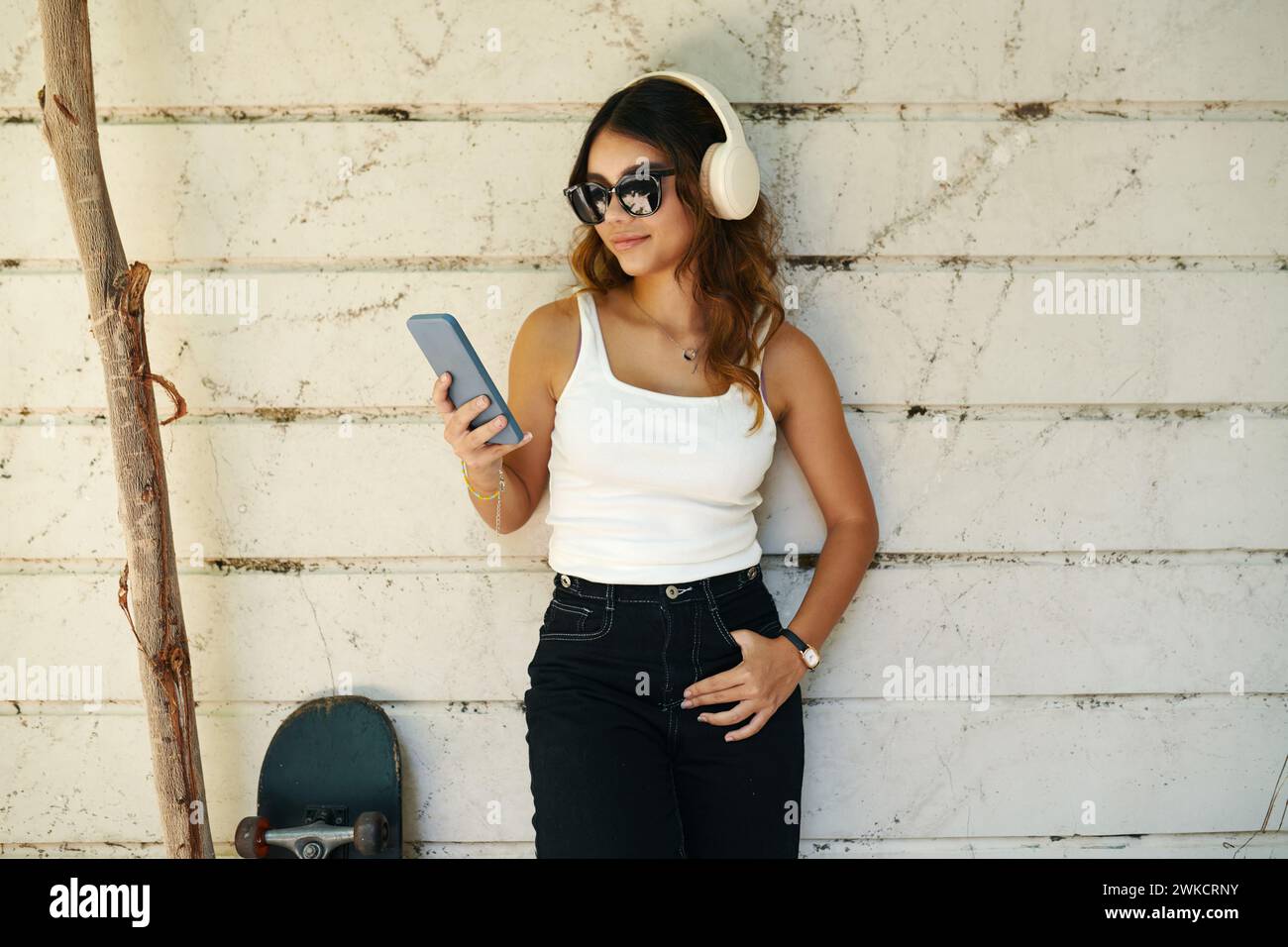 Portrait de fille souriante écoutant de la musique de playlist sur son téléphone Banque D'Images