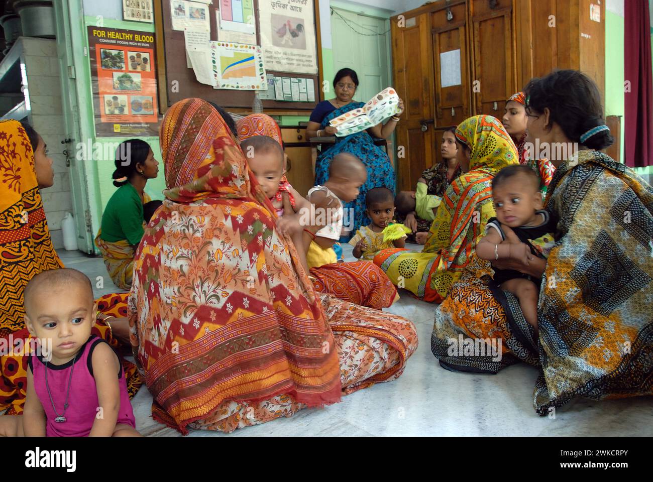 La moitié des enfants indiens de moins de cinq ans souffrent de malnutrition. Être sous-alimenté affecte non seulement physiquement, mais aussi le développement mental de l'enfant. CINI adopte une approche durable pour lutter contre la malnutrition infantile, en mettant l'accent sur la sensibilisation et l'intervention constructive. C'est la première clinique en Inde créée dans le seul but de traiter les enfants souffrant de malnutrition, et les mères ont reçu des conseils sur ce qu'il fallait nourrir leurs enfants. Beaucoup de ces mères ne sont guère plus que des enfants eux-mêmes et sont très mal nourries. Thakurpukur, Kolkata, Bengale occidental, Inde. Banque D'Images