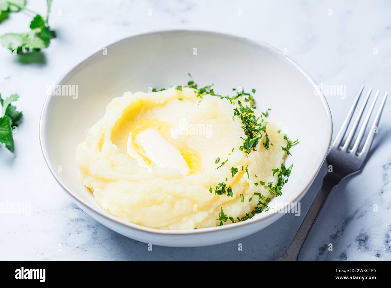 Purée de pommes de terre classique avec beurre et herbes, fond de marbre blanc. Banque D'Images