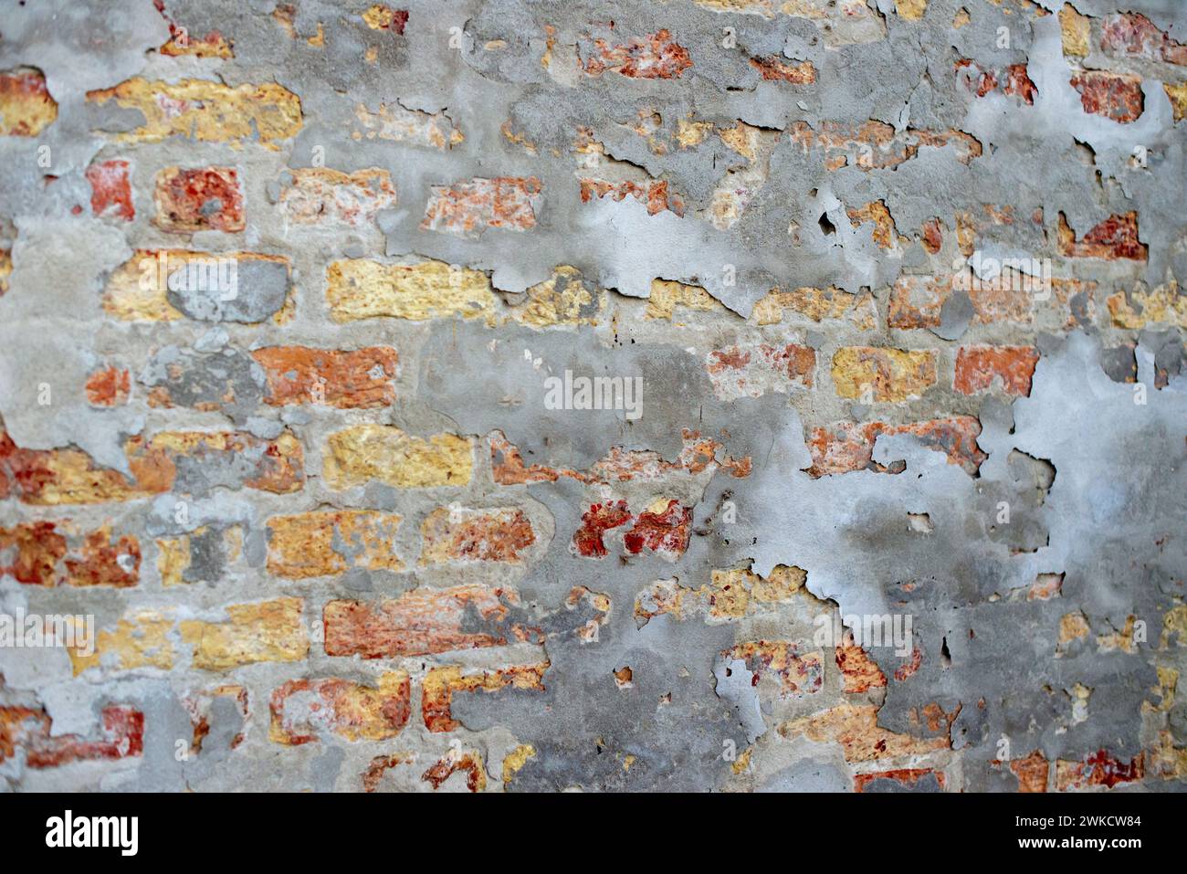 Un mur de briques vieillies avec des taches blanches, usé et altéré. Banque D'Images