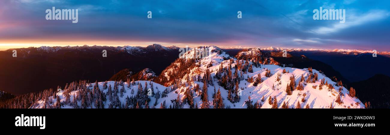 Une vue panoramique aérienne du paysage montagneux canadien en hiver au coucher du soleil. Banque D'Images