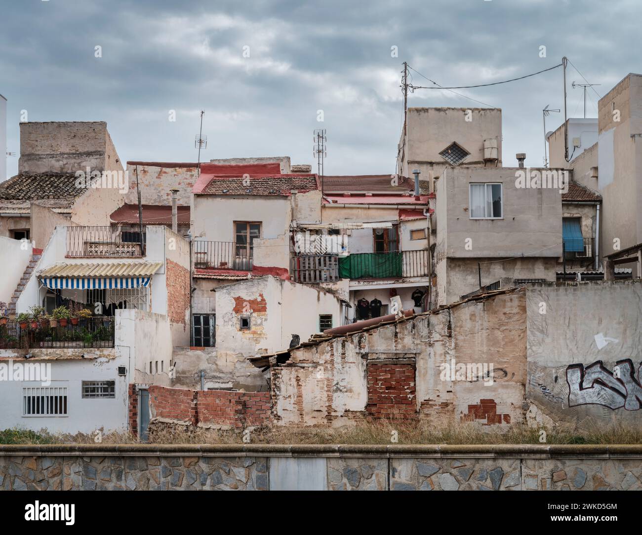 Certains des bâtiments délabrés qui bordent la rive de la rivière à Orihuela, Alicante, Espagne. Banque D'Images