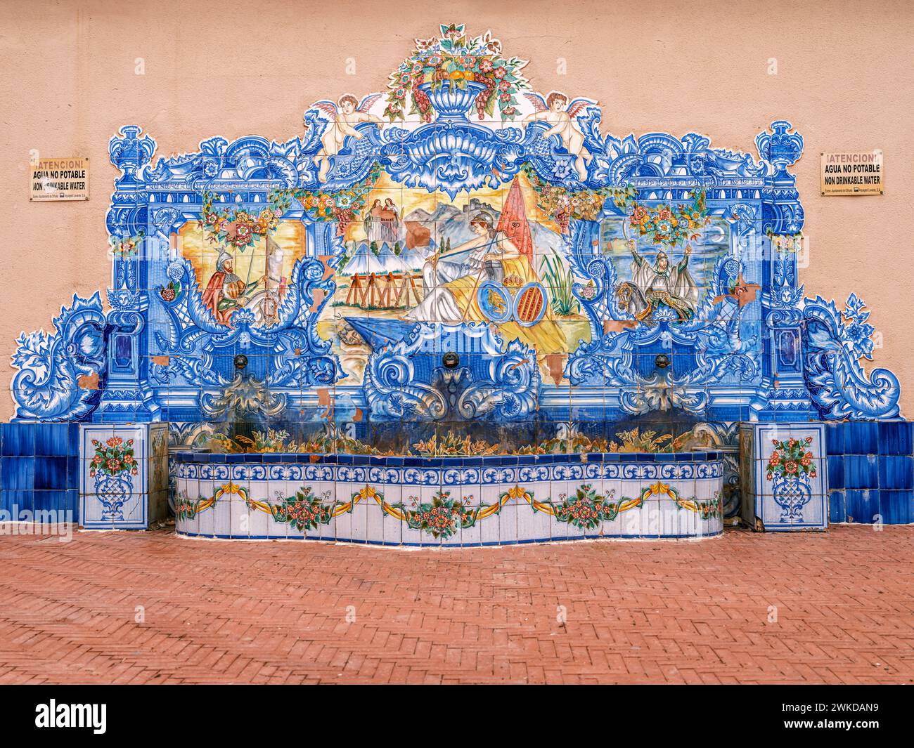 Une pièce d'eau carrelée en céramique ornée et un banc dans la partie ancienne d'Orihuela, Alicante, Espagne. Banque D'Images