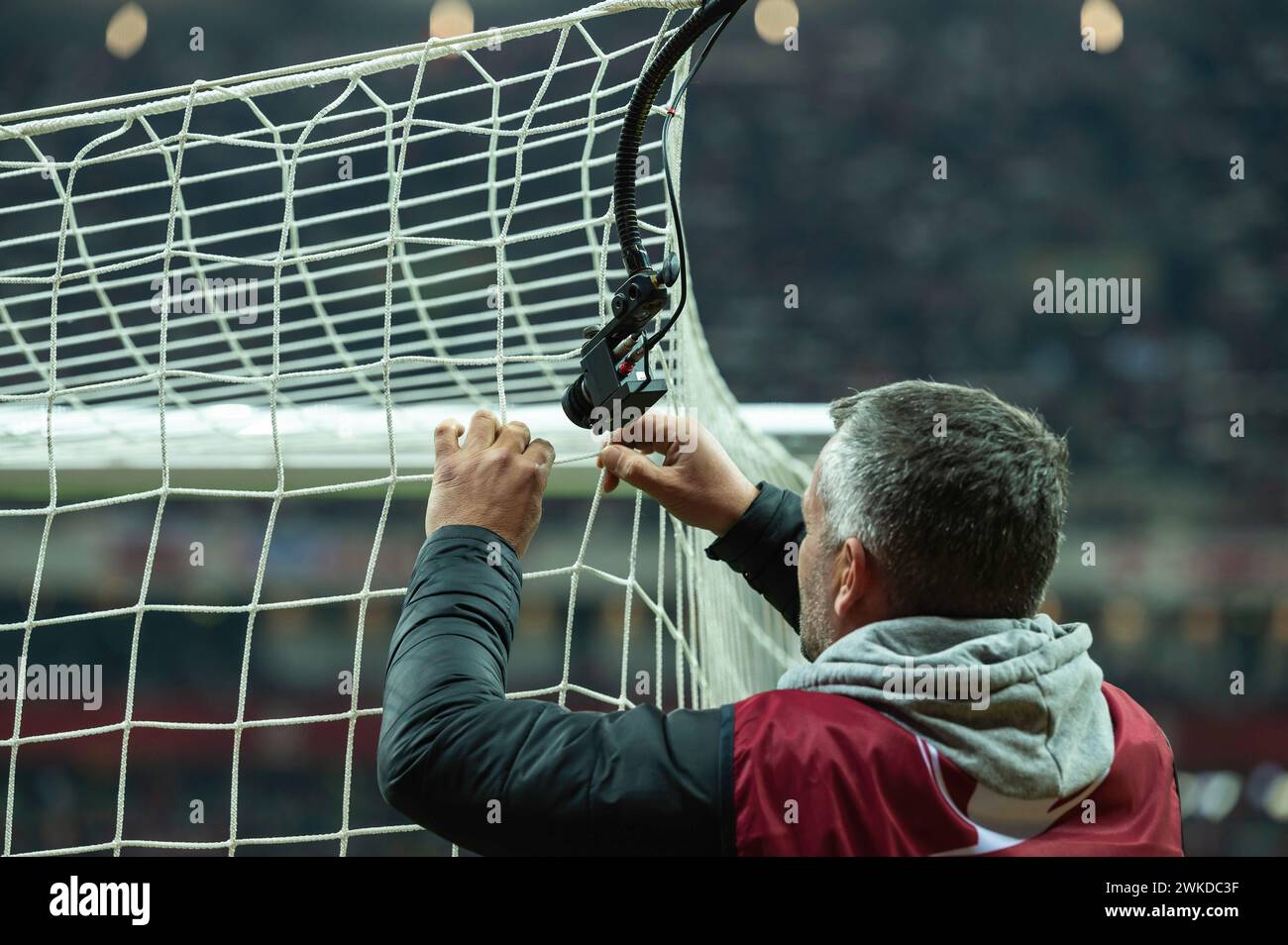 L'homme installe une caméra de télévision dans un but de football Banque D'Images