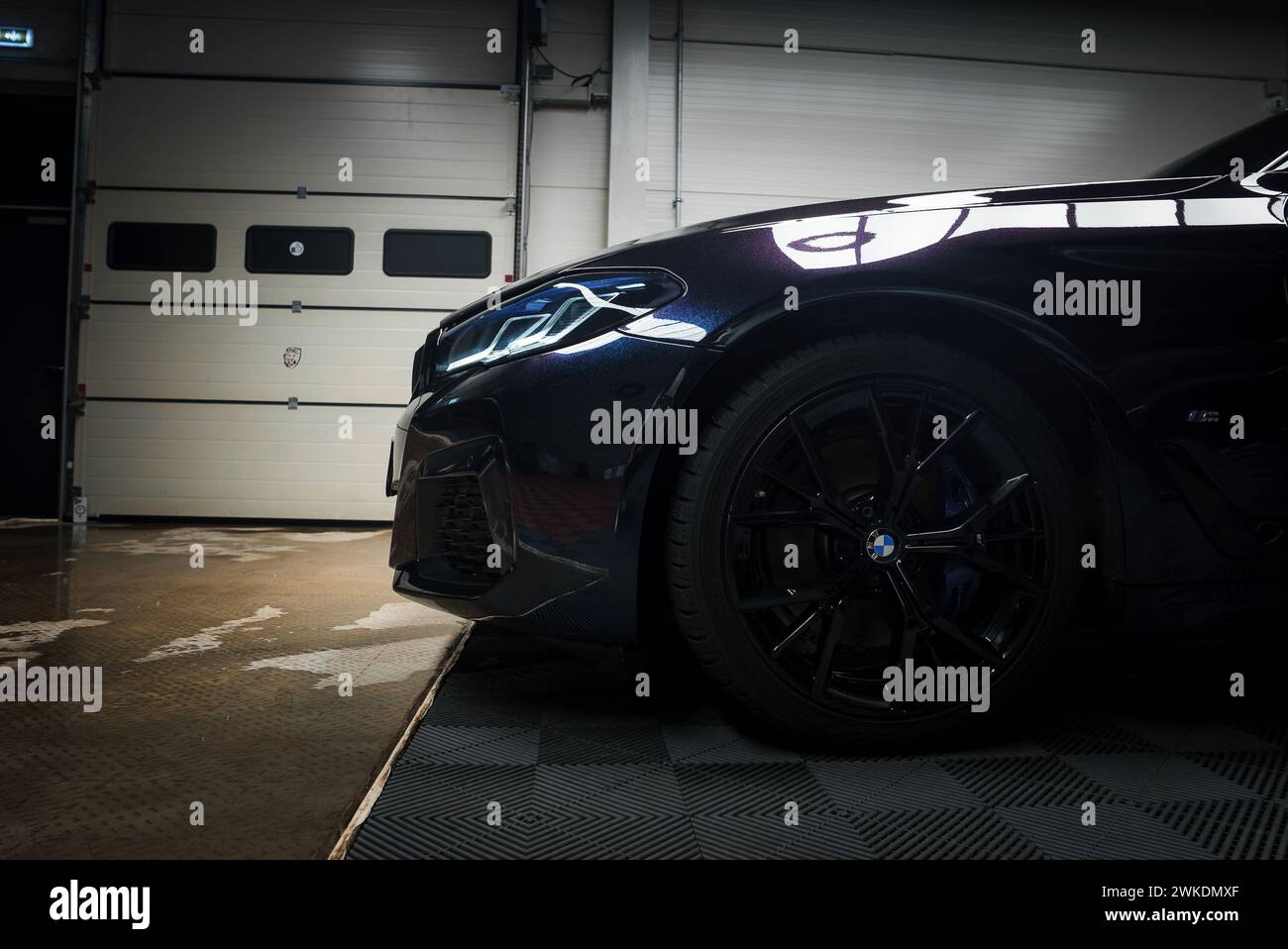 Gros plan de Black BMW dans un garage intérieur avec phares LED et roue sportive Banque D'Images