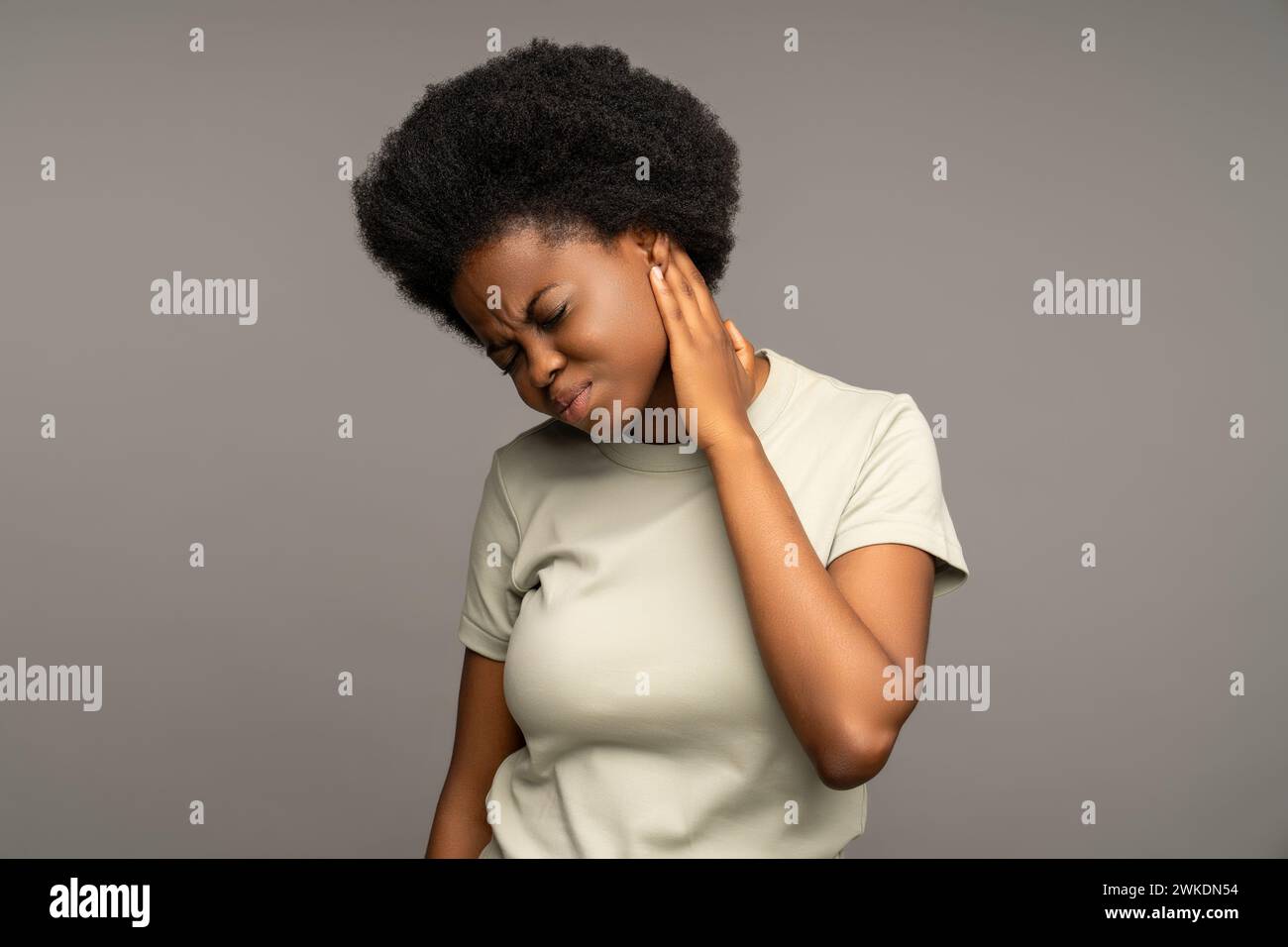 Femme noire touchant l'oreille douloureuse, présentant des symptômes d'otite, nécessitant un traitement oto-rhino-laryngologiste Banque D'Images