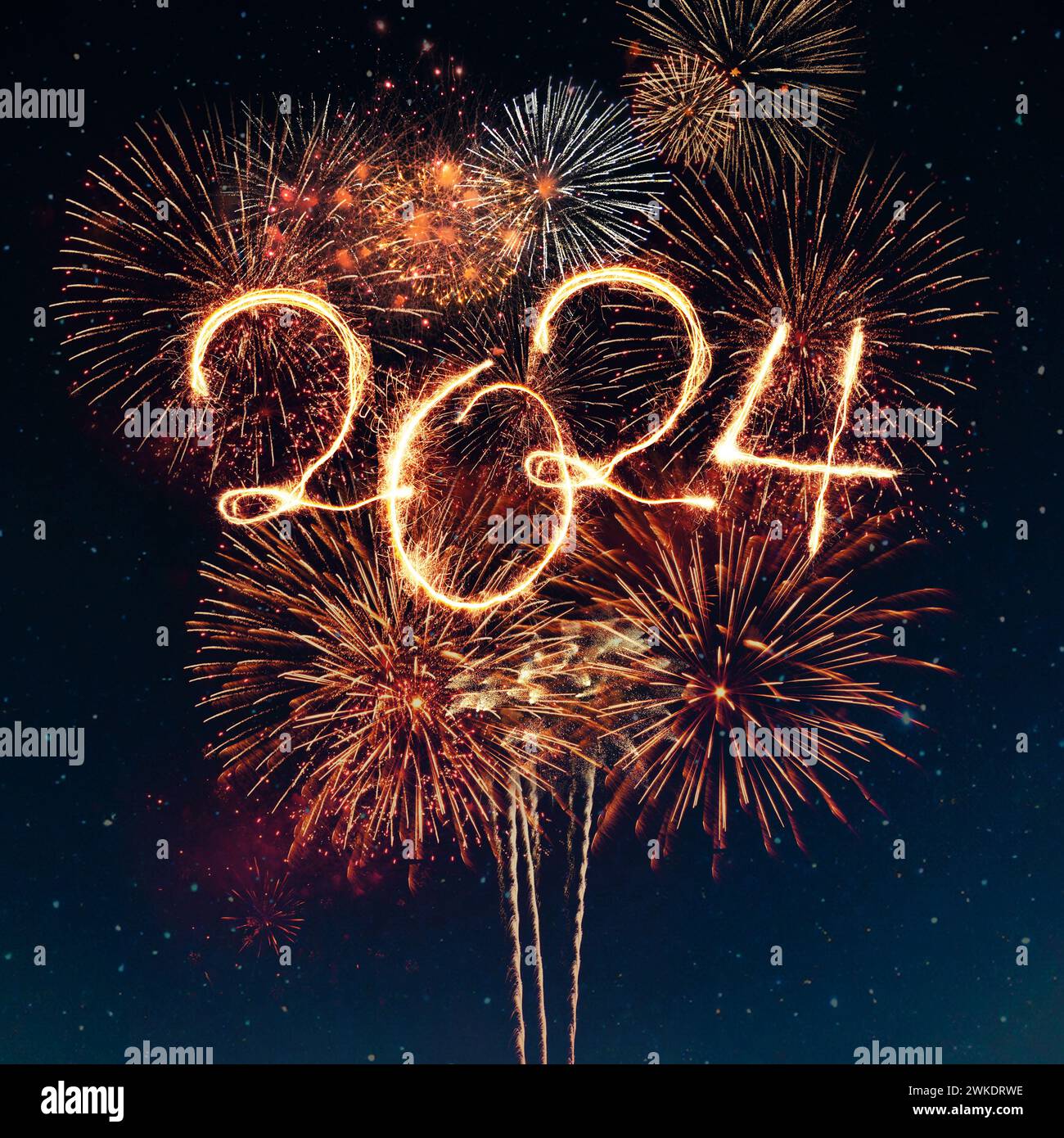 Bonne année 2024. Des feux d'artifice dorés festifs explosent dans le ciel étoilé Banque D'Images