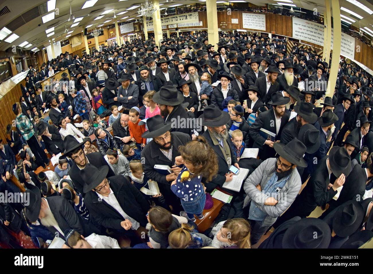 Une grande foule d'hommes et d'enfants juifs orthodoxes se rassemblent dans la synagogue principale de Chabad à Crown Heights, Brooklyn pour les services de Chanukkah. Banque D'Images