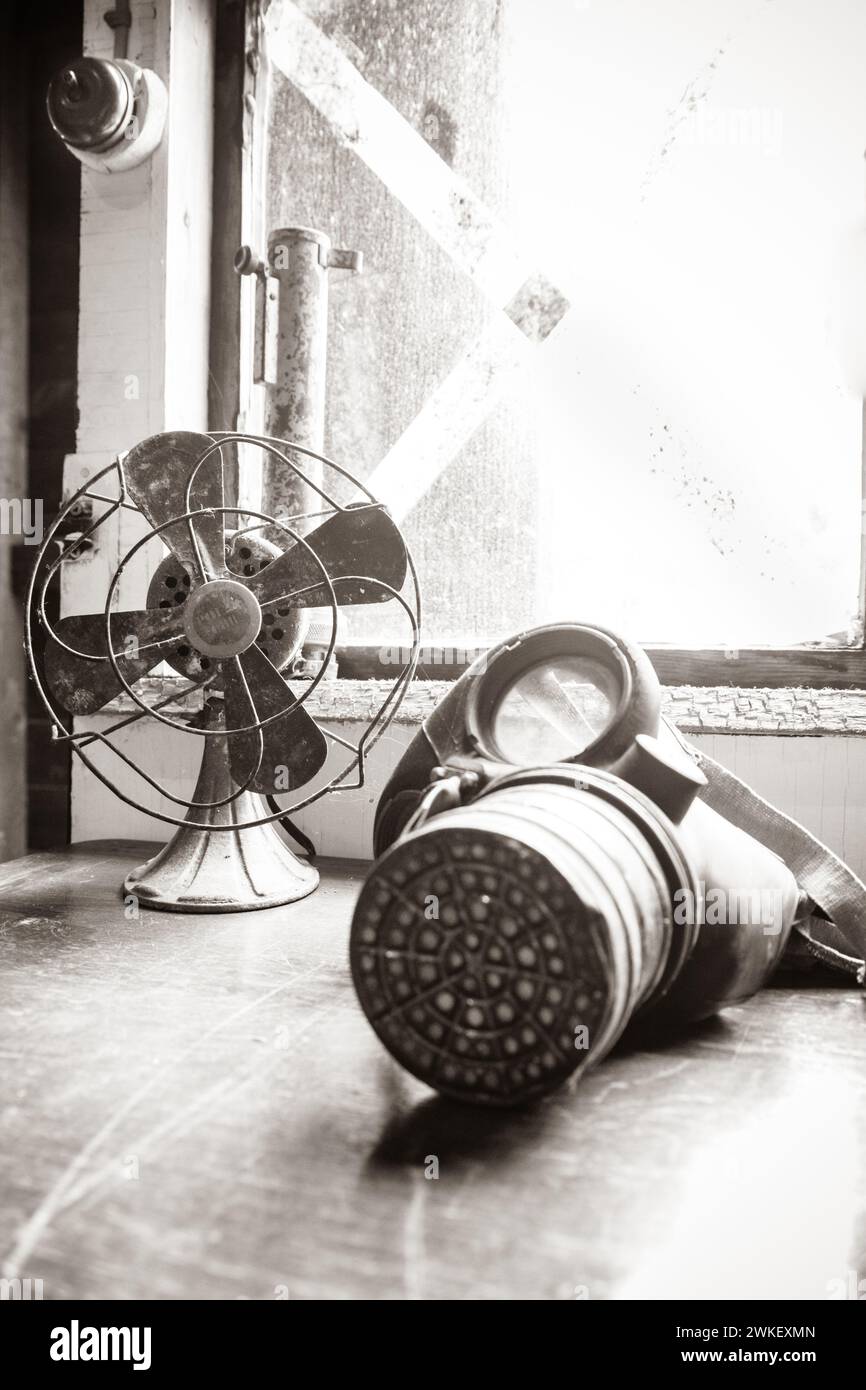 Ventilateur vintage et masque à gaz de la seconde Guerre mondiale posé sur un bureau en temps de guerre dans la Vale. Banque D'Images