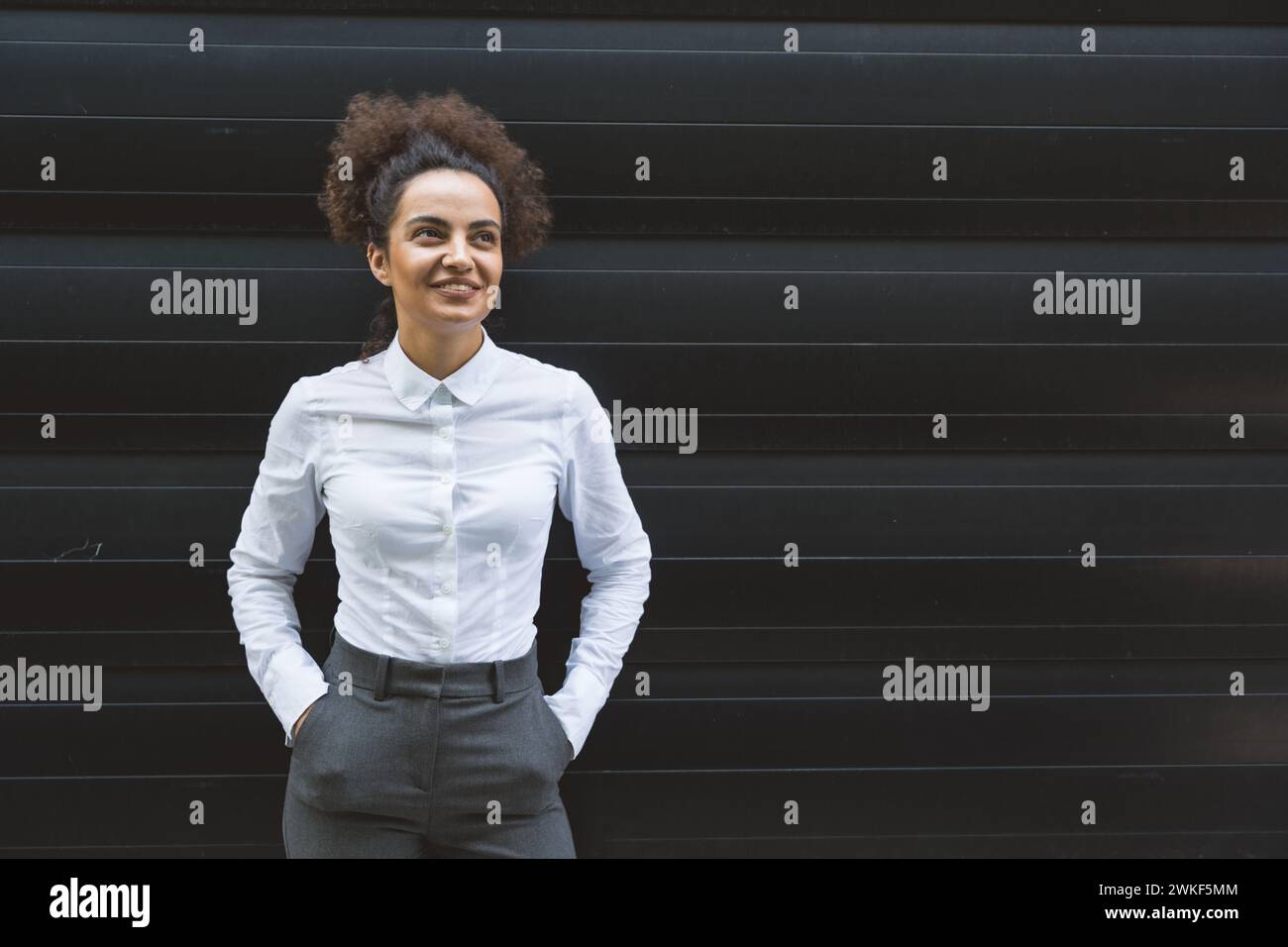 Portrait de jeune femme d'affaires confiante et prospère debout à l'extérieur de l'immeuble de bureaux. Homme d'affaires indépendant instruit chef d'équipe féminin posant Banque D'Images