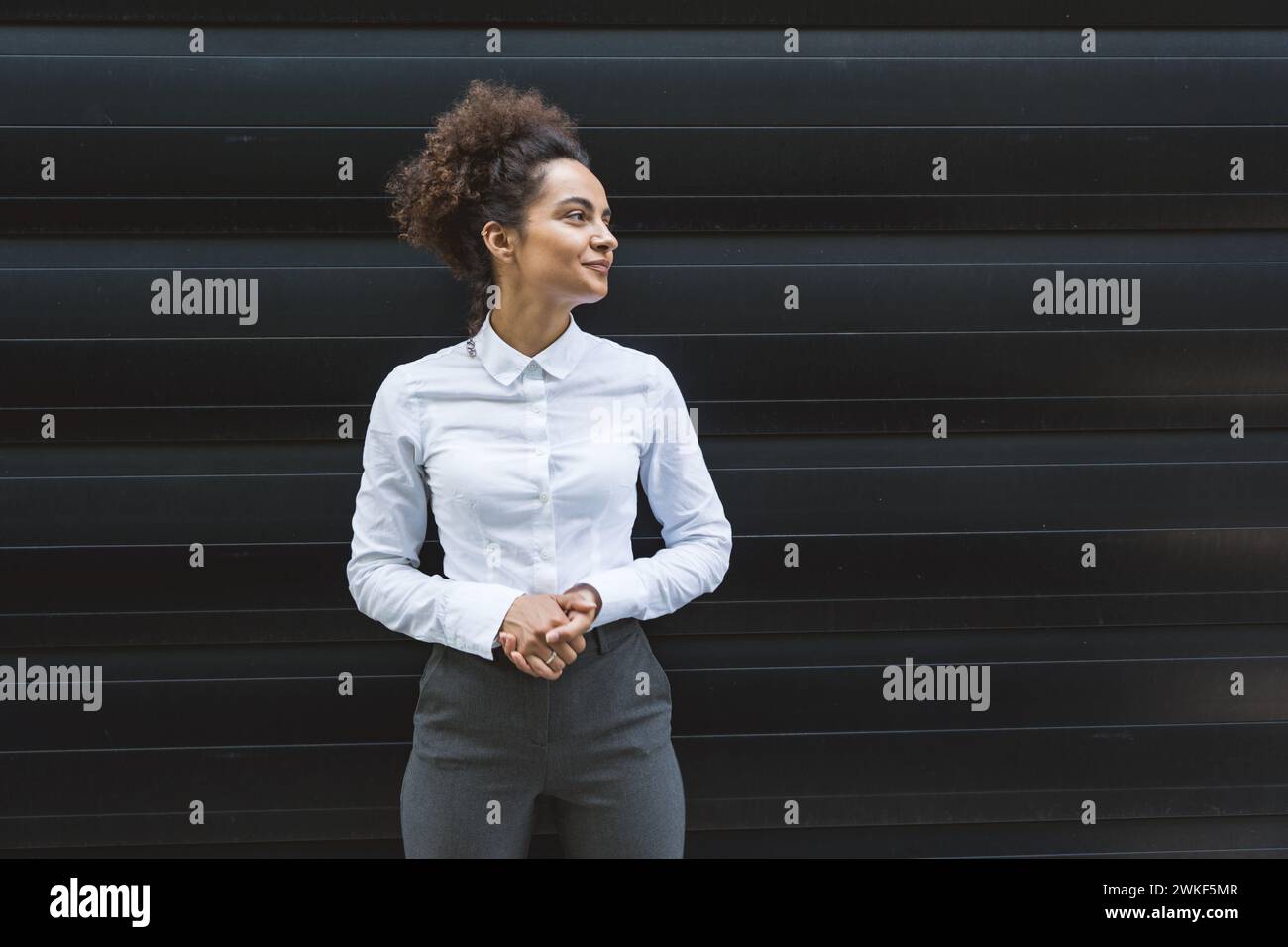 Portrait de jeune femme d'affaires confiante et prospère debout à l'extérieur de l'immeuble de bureaux. Homme d'affaires indépendant instruit chef d'équipe féminin posant Banque D'Images