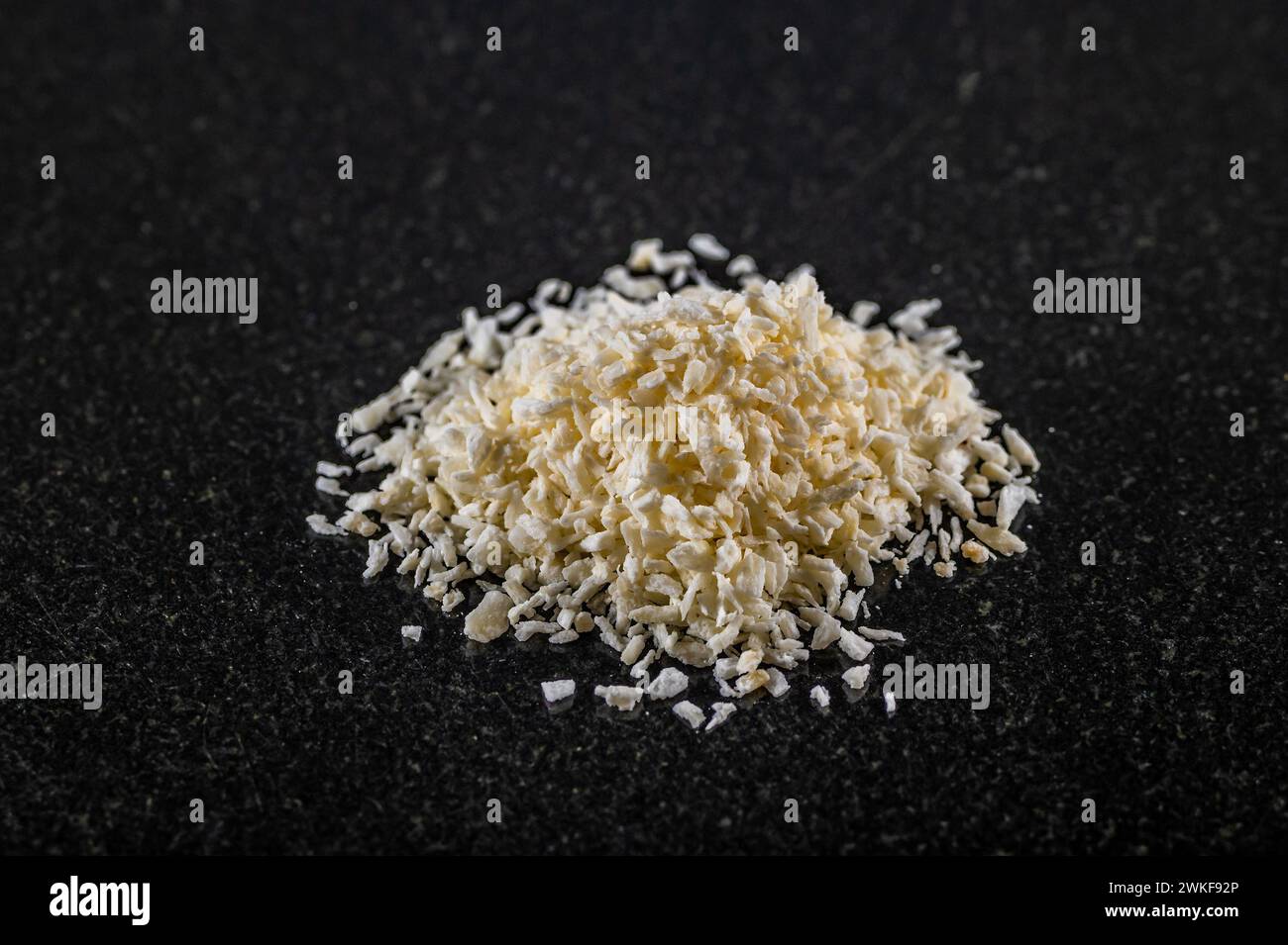 Une vue rapprochée d'un tas de noix de coco desséchée sur un plateau de marbre foncé Banque D'Images
