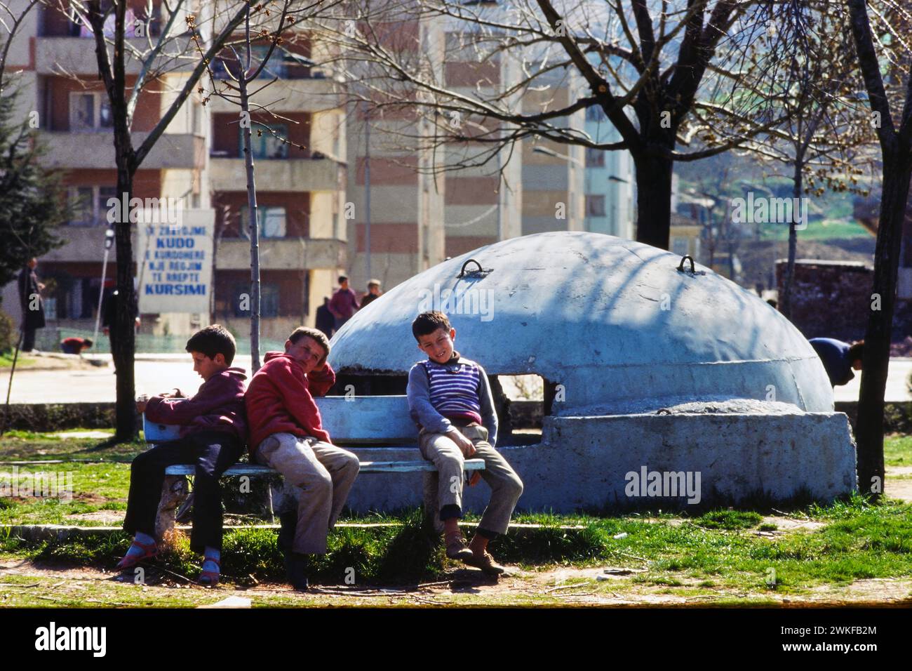 Albanie, Tirana, mars 1986 : des enfants assis devant un bunker de l'époque communiste du gouvernement d'Enver Hoxha pour fournir une protection contre une invasion étrangère Banque D'Images