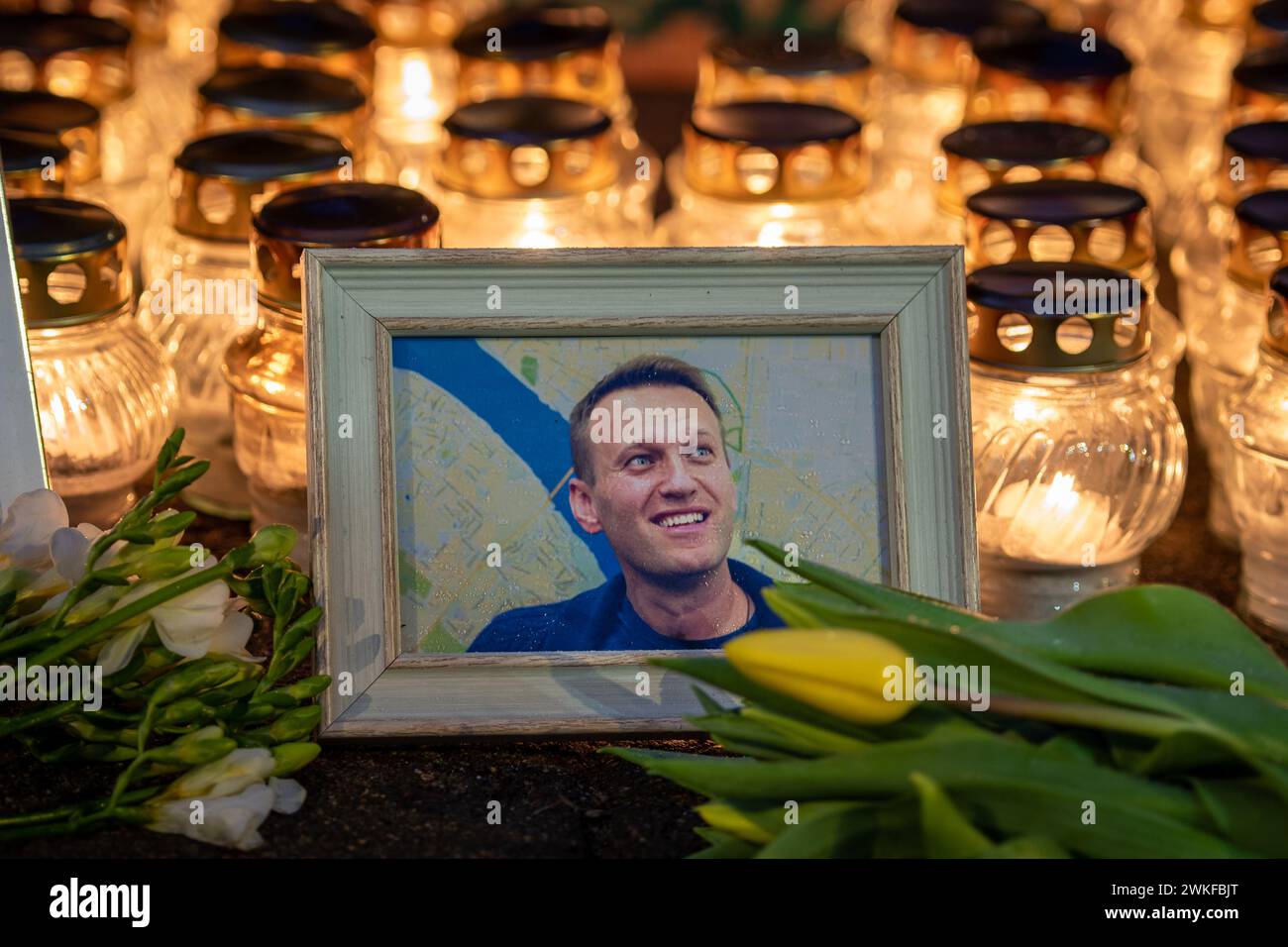 Fleurs et bougies posées au mémorial spontané du chef de l'opposition russe Alexei Navalny, avec un portrait souriant mouillé par la neige et les gouttes de pluie Banque D'Images