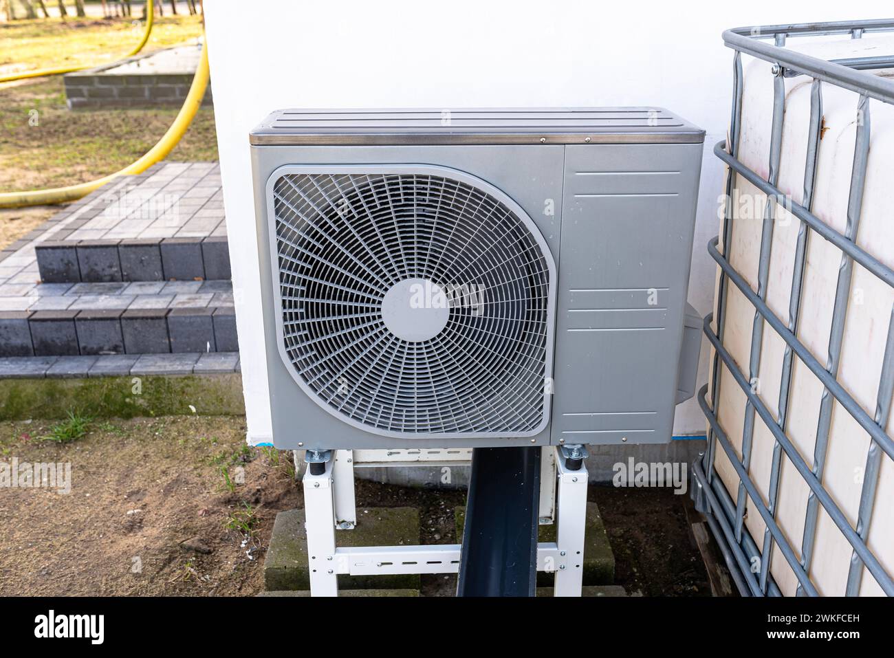 Unité extérieure d'une pompe à chaleur à air de faible puissance située devant la maison. Banque D'Images