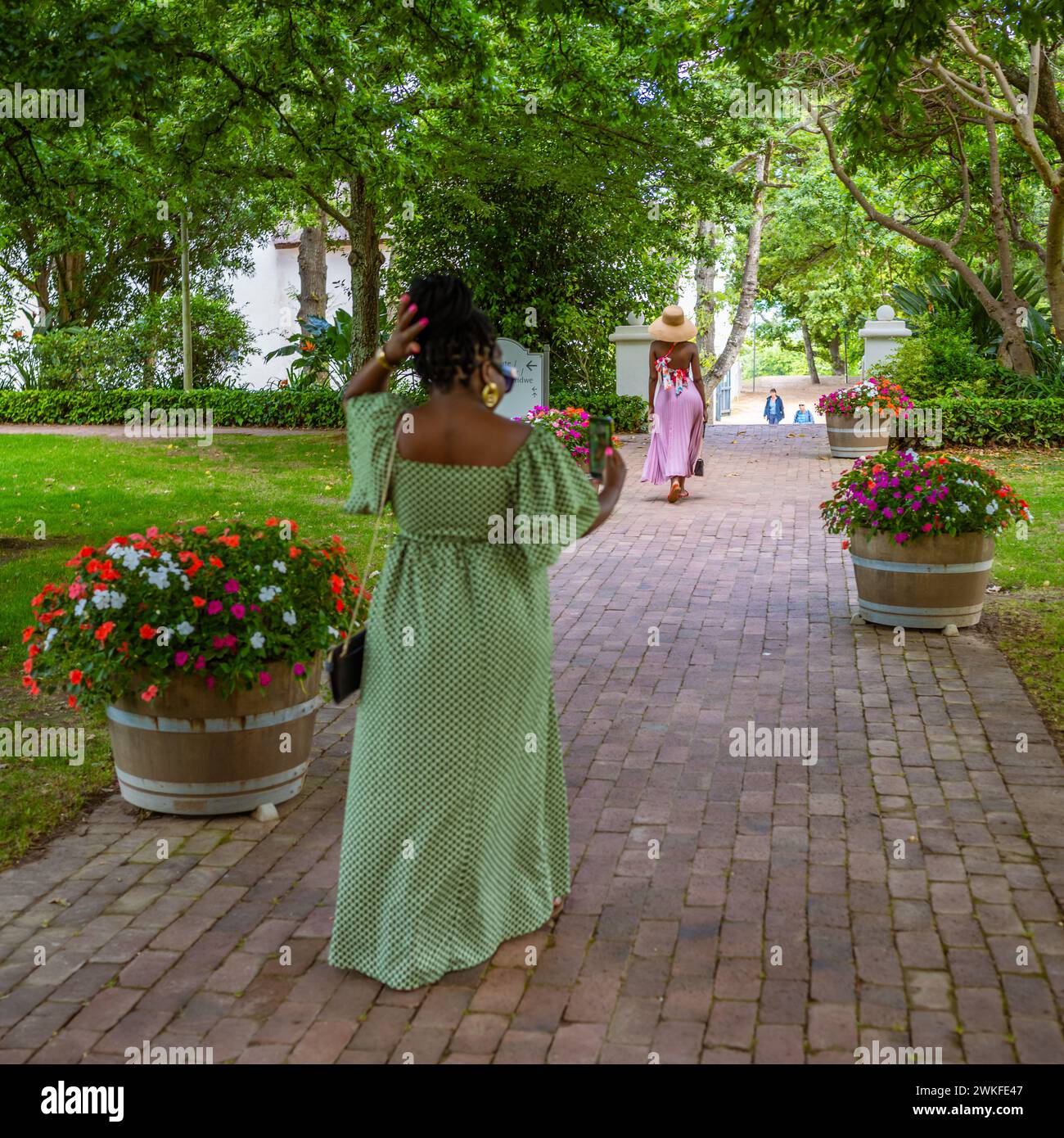 Deux femmes élégantes dans de longues robes maxi élégantes marchant dans un parc vinicole Banque D'Images