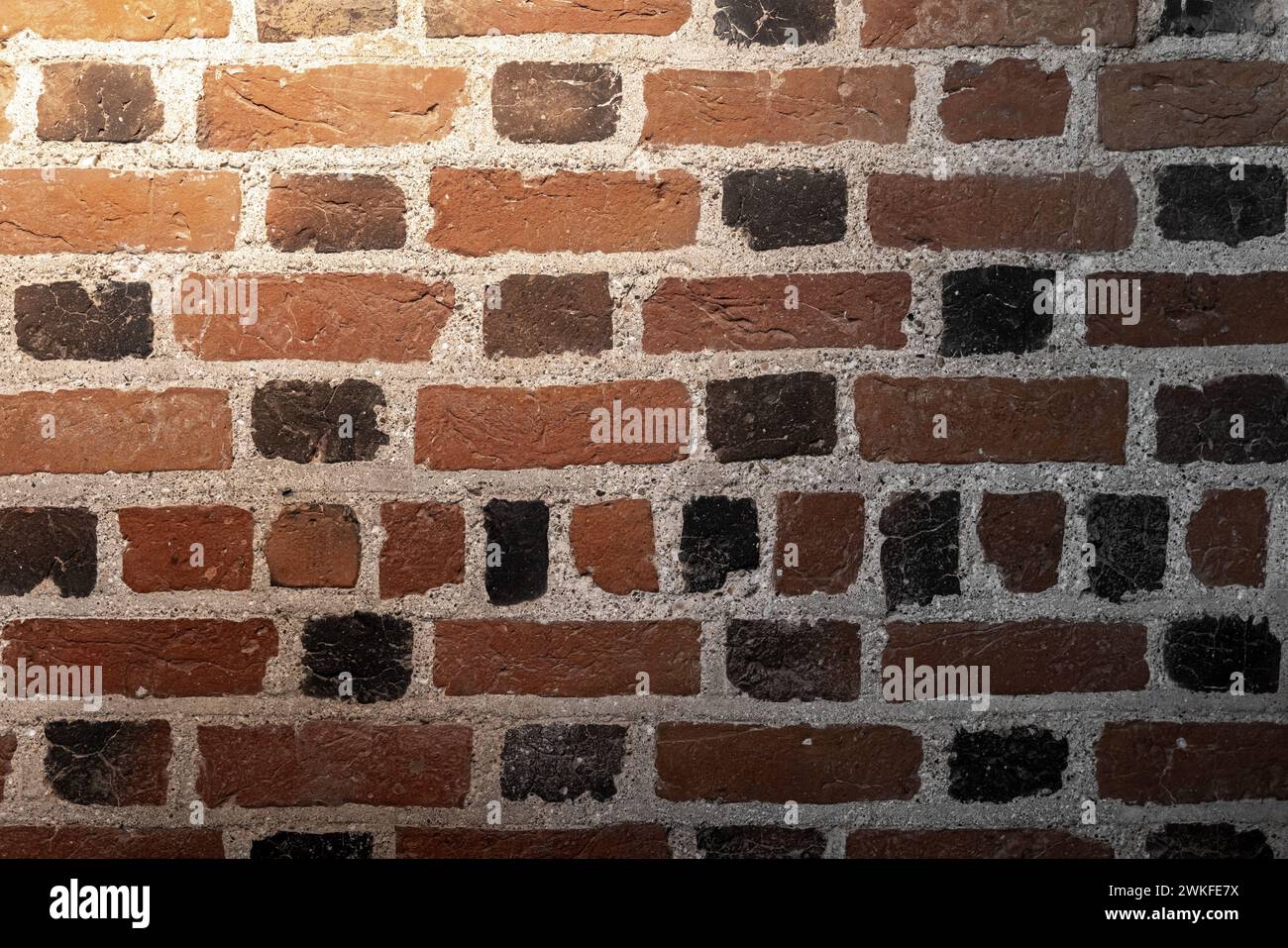 Mur de briques foncées antique grungy avec projecteur, texture de photo de fond Banque D'Images