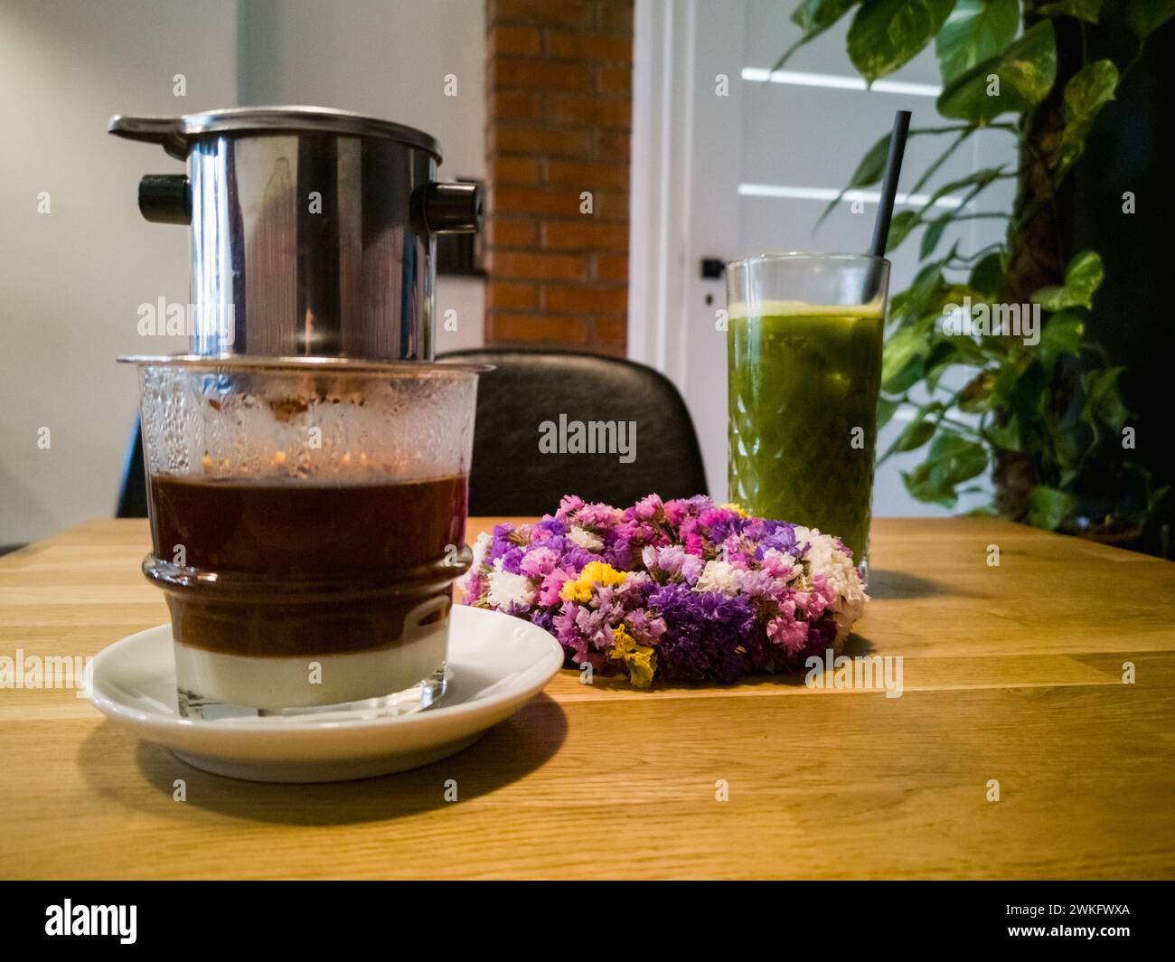 Verre avec du café vietnam avec du lait condensé avec machine à café sur elle et thé matcha glacé vert dans un petit café Banque D'Images