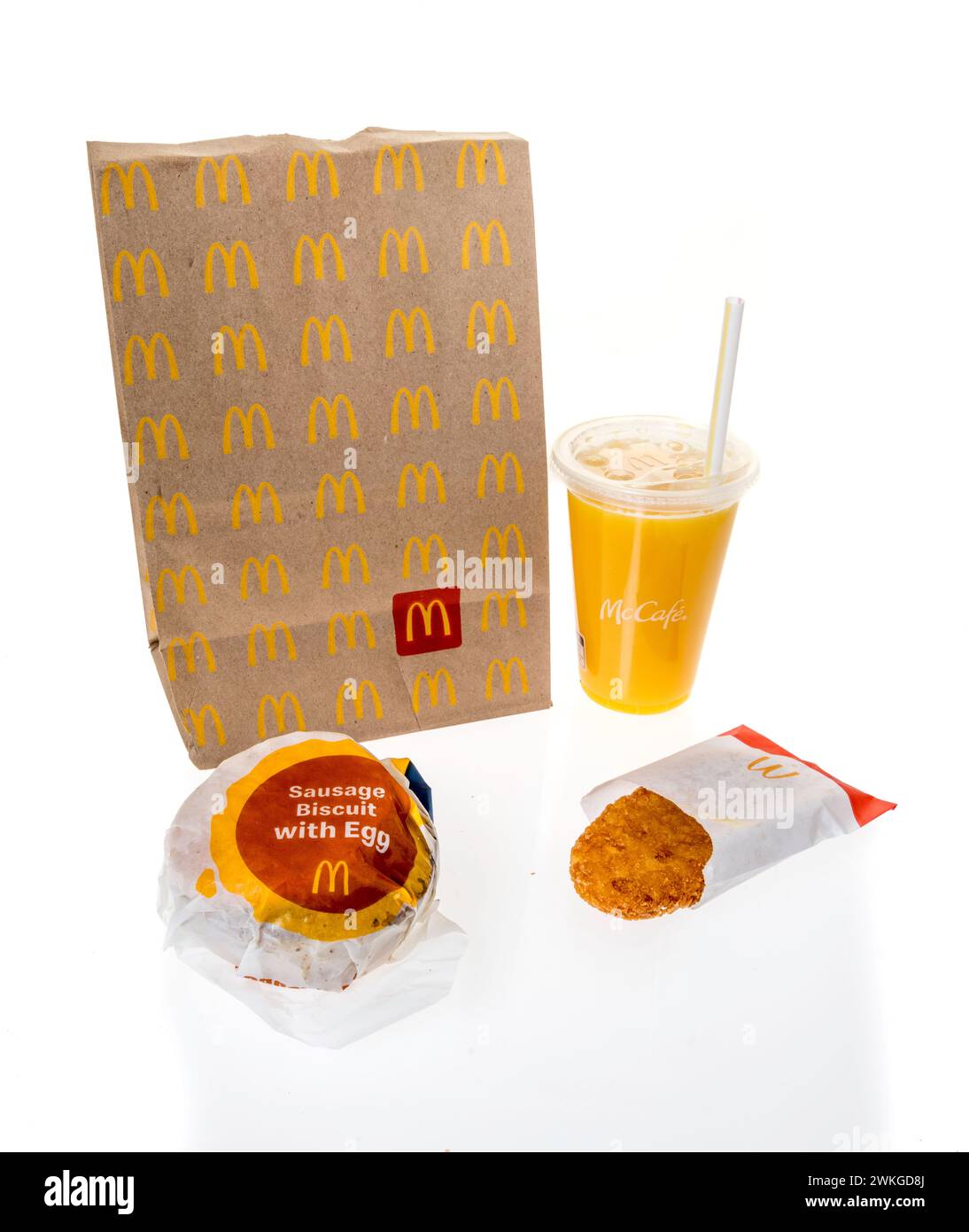 Winneconne, WI - 20 février 2024 : un forfait de petit déjeuner McDonalds comprenant du jus d'orange et du biscuit aux œufs à la saucisse sur fond isolé Banque D'Images