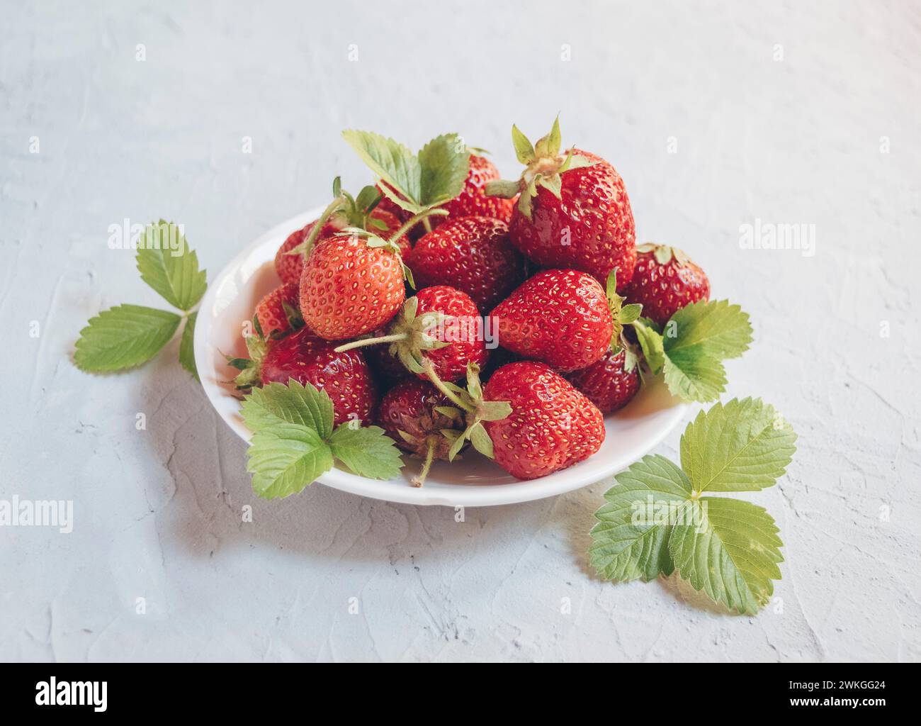 Fraise . Végétalien propre manger, régime alcalin. Vue de dessus. Maquette. récolte fraîche de fraises. Fraises fraîches mûres dans une assiette blanche. Vue depuis un Banque D'Images