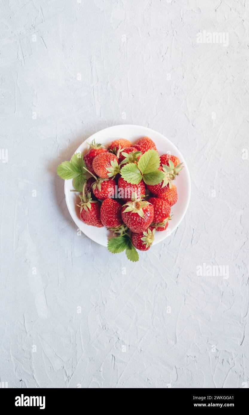 Fraise . Végétalien propre manger, régime alcalin. Vue de dessus. Maquette. récolte fraîche de fraises. Fraises fraîches mûres dans une assiette blanche. Vue depuis un Banque D'Images