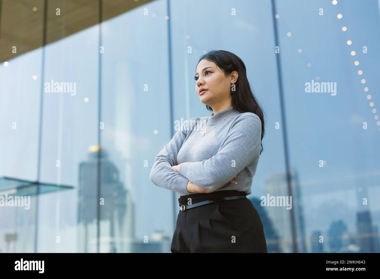 portrait d'affaires confiantes femmes indiennes debout againt de grandes fenêtres en verre immeuble de bureaux croisement de bras Banque D'Images
