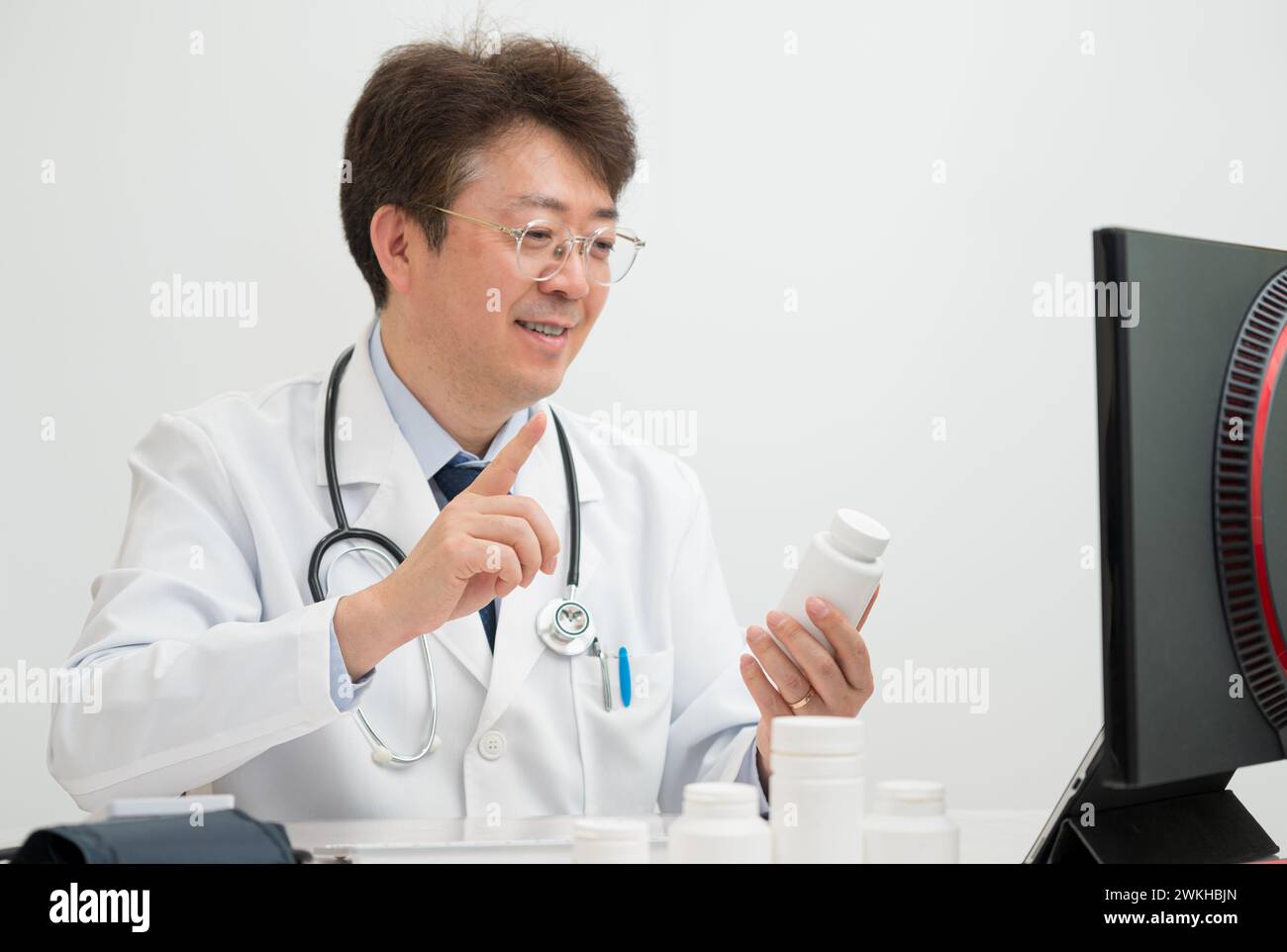 Un médecin d'âge moyen pratiquant la télémédecine à l'aide d'un ordinateur Banque D'Images