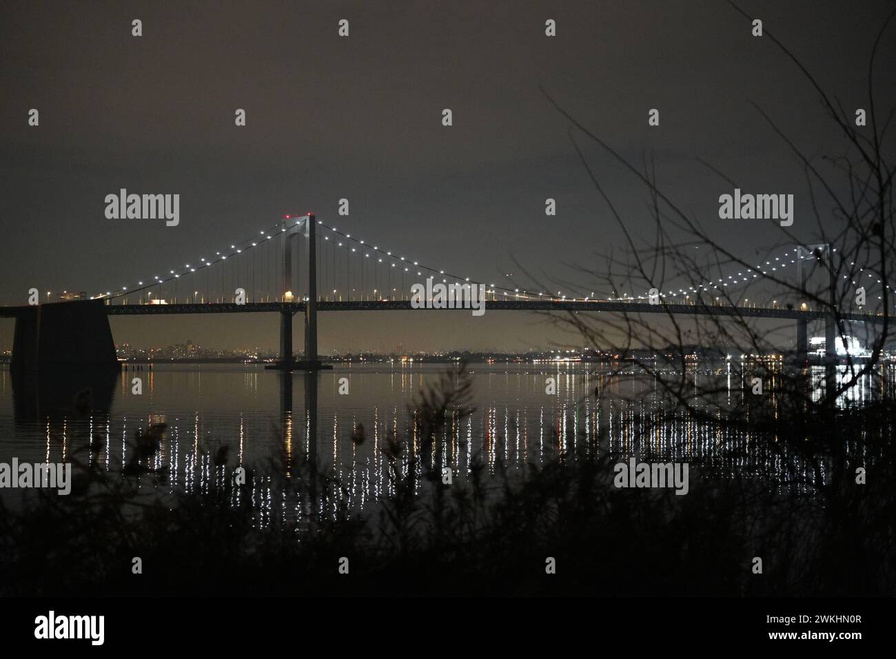 Le Bay Bridge illuminé se détache sur un ciel sombre au-dessus de l'eau Banque D'Images