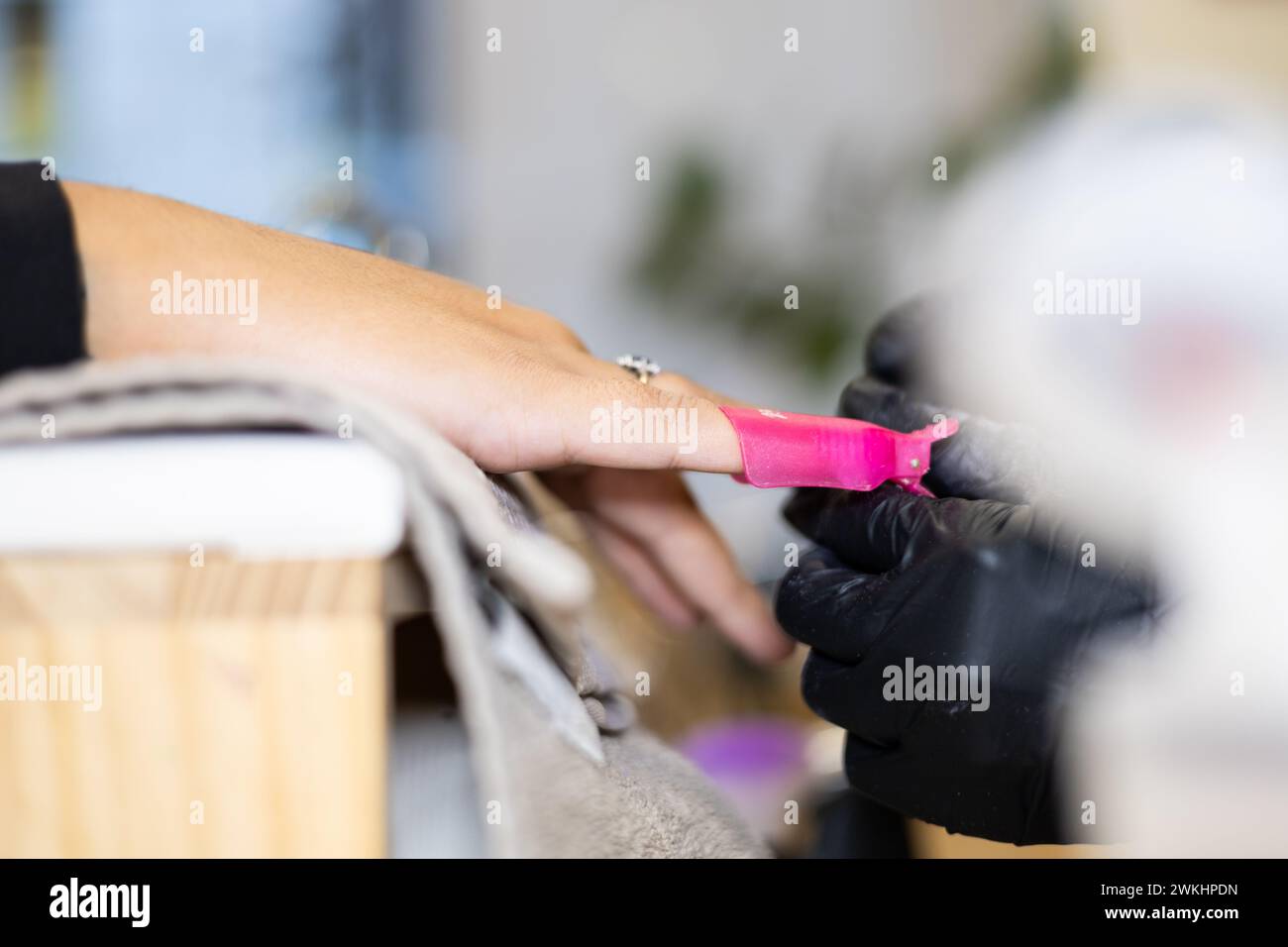Manucure faisant la manucure de son client en enlevant le vernis des ongles. Traitement de manucure professionnel dans un salon de beauté. Hygiène et soins des mains dans l'industrie de la beauté. Banque D'Images