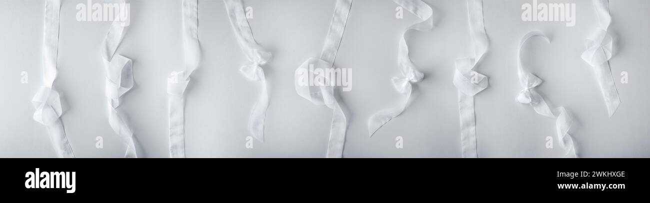 Collection de bandes blanches de tissu de tulle avec diverses formes avec des arcs et des nœuds comme décoration de fond pour les événements sur un fond blanc. Vue de dessus Banque D'Images