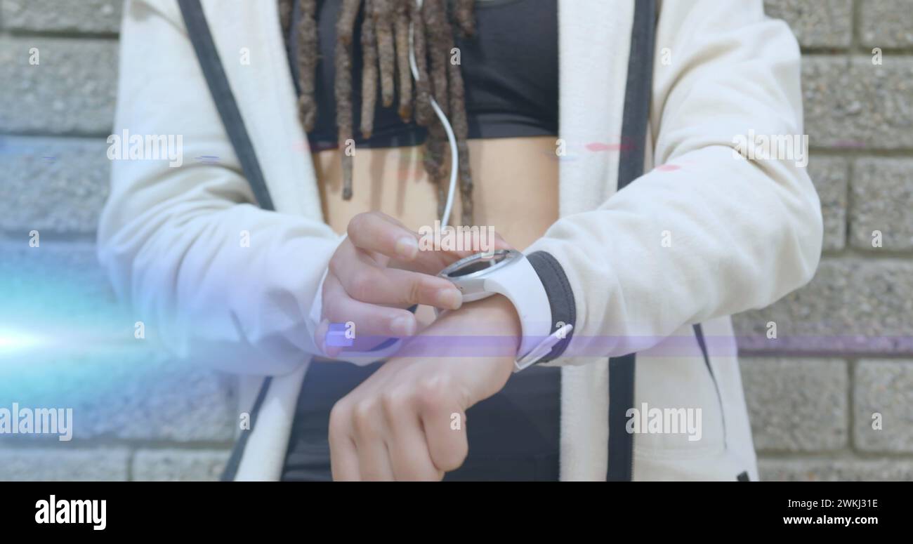 Image de faisceaux de lumière bleue sur la section médiane de la femme en utilisant smartwatch Banque D'Images